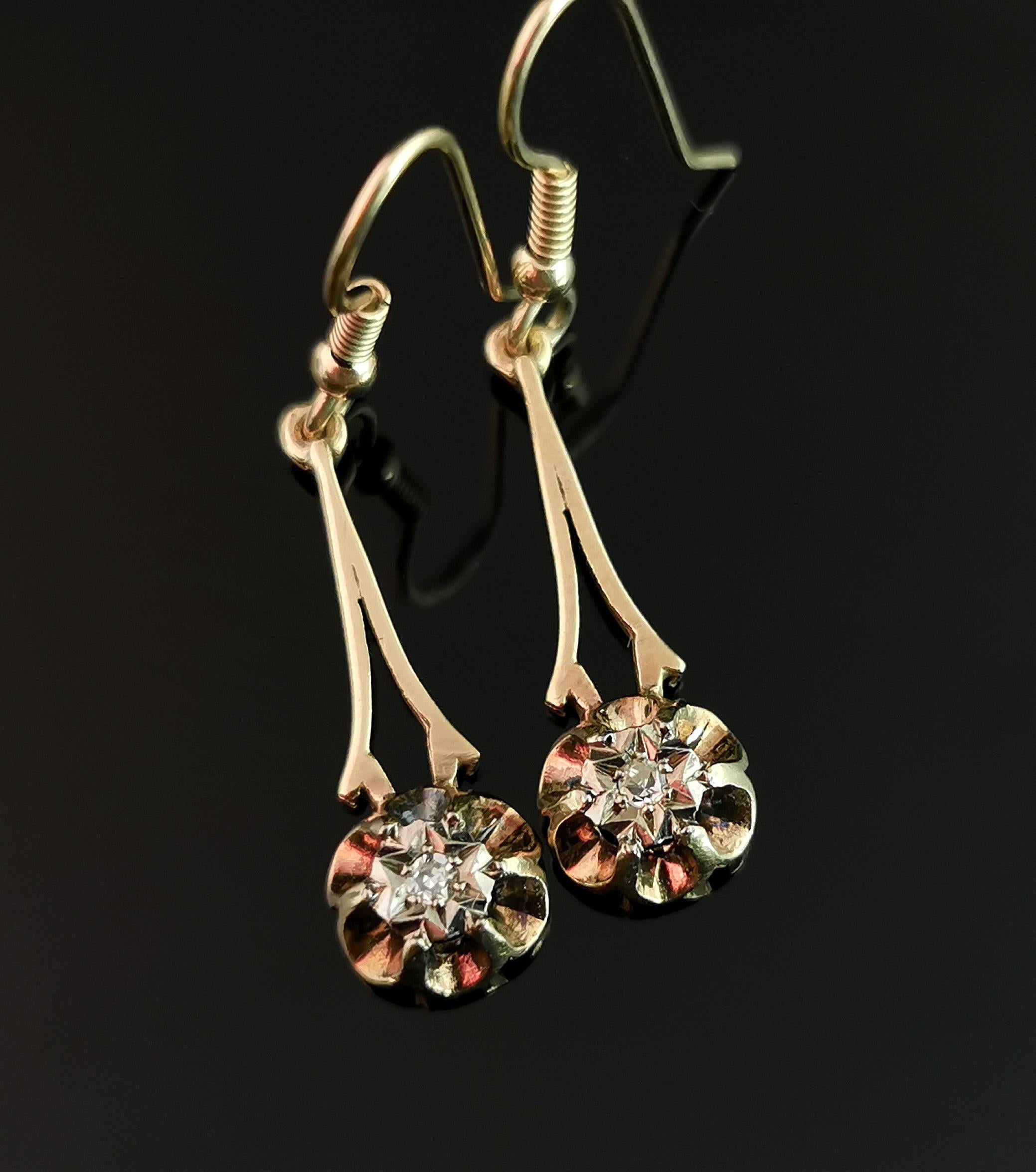 A beautiful pair of Antique 9kt yellow gold diamond drop earrings.

Beautiful tapering golden drops each set with a single old cut diamond, the diamonds housed in a silver star cut setting and the drops having an almost floral design.

The earrings