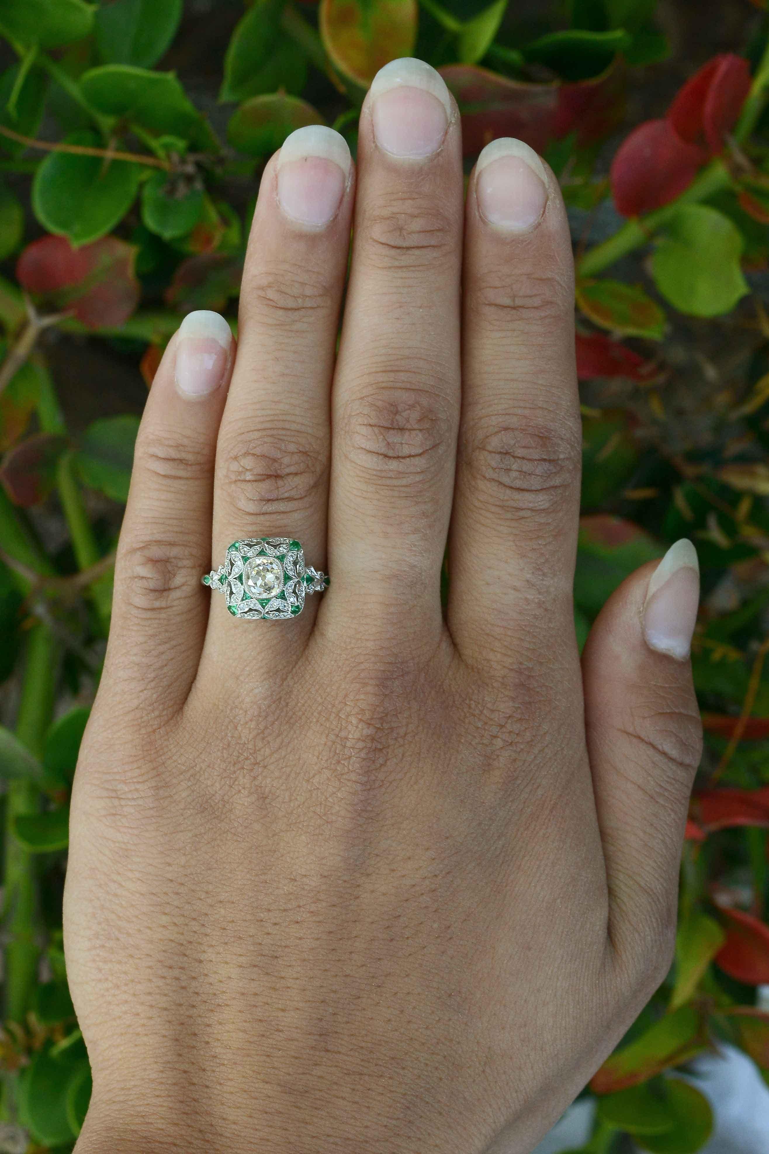 An diamond emerald engagement ring created as a micro mosaic dome, so mesmerizing and detailed. We love the milgrained leaves that embrace this fiery, dazzling, 1.12 carat old mine cut cushion diamond with a romantic, openwork design that rises like