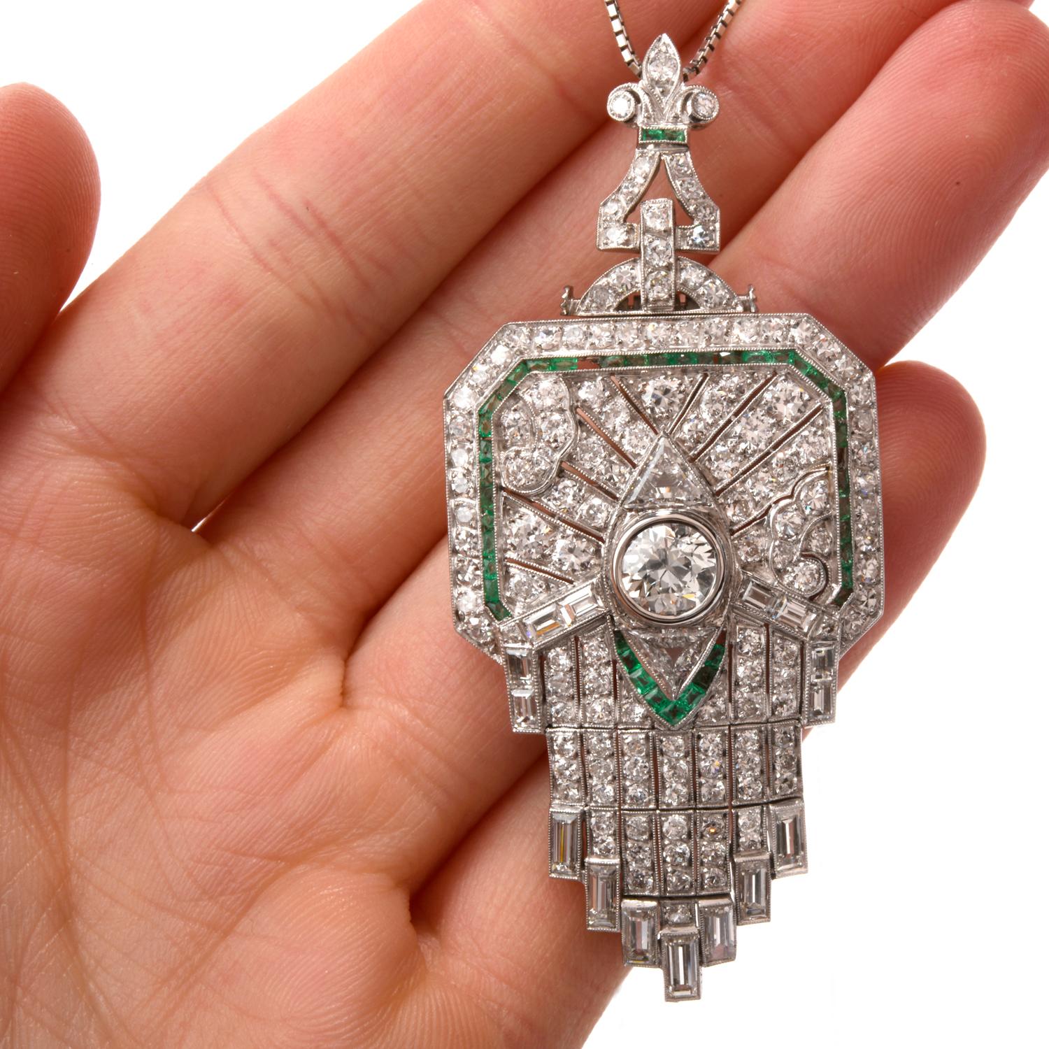 This Diamond and Emerald Brooch/Pendant was inspired in an Art Deco design featuring a Fleur De Lis atop and was crafted in Luxurious Platinum.   This stately piece is able to be worn as a brooch or pendant.

Featured in the center is one European