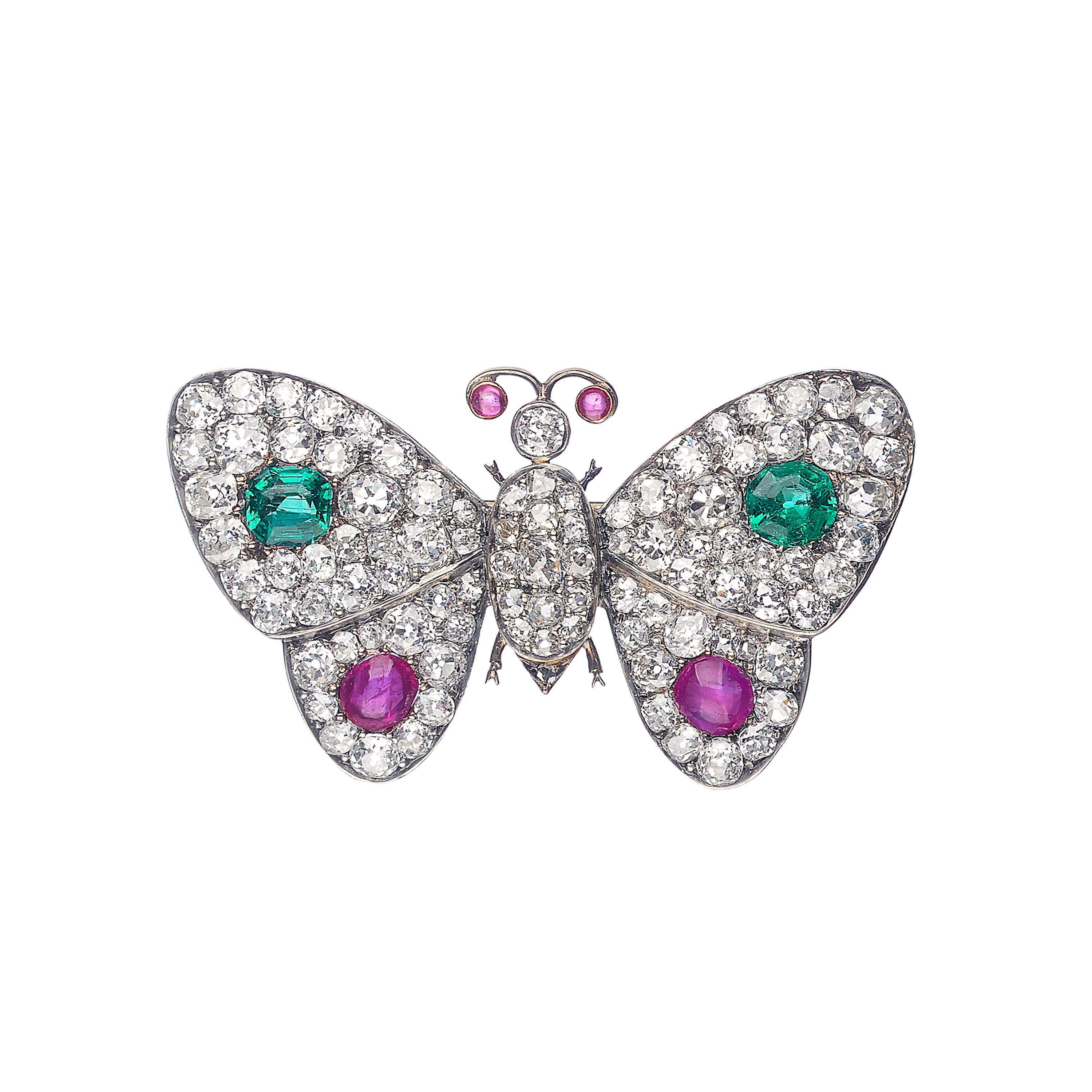 An antique butterfly brooch, with old-cut diamond pavé set thorax and wings, with a faceted emerald in each top wing, with a total weight of approximately 1.30 carats and a cabochon-cut ruby in each lower wing, with a total weight of approximately