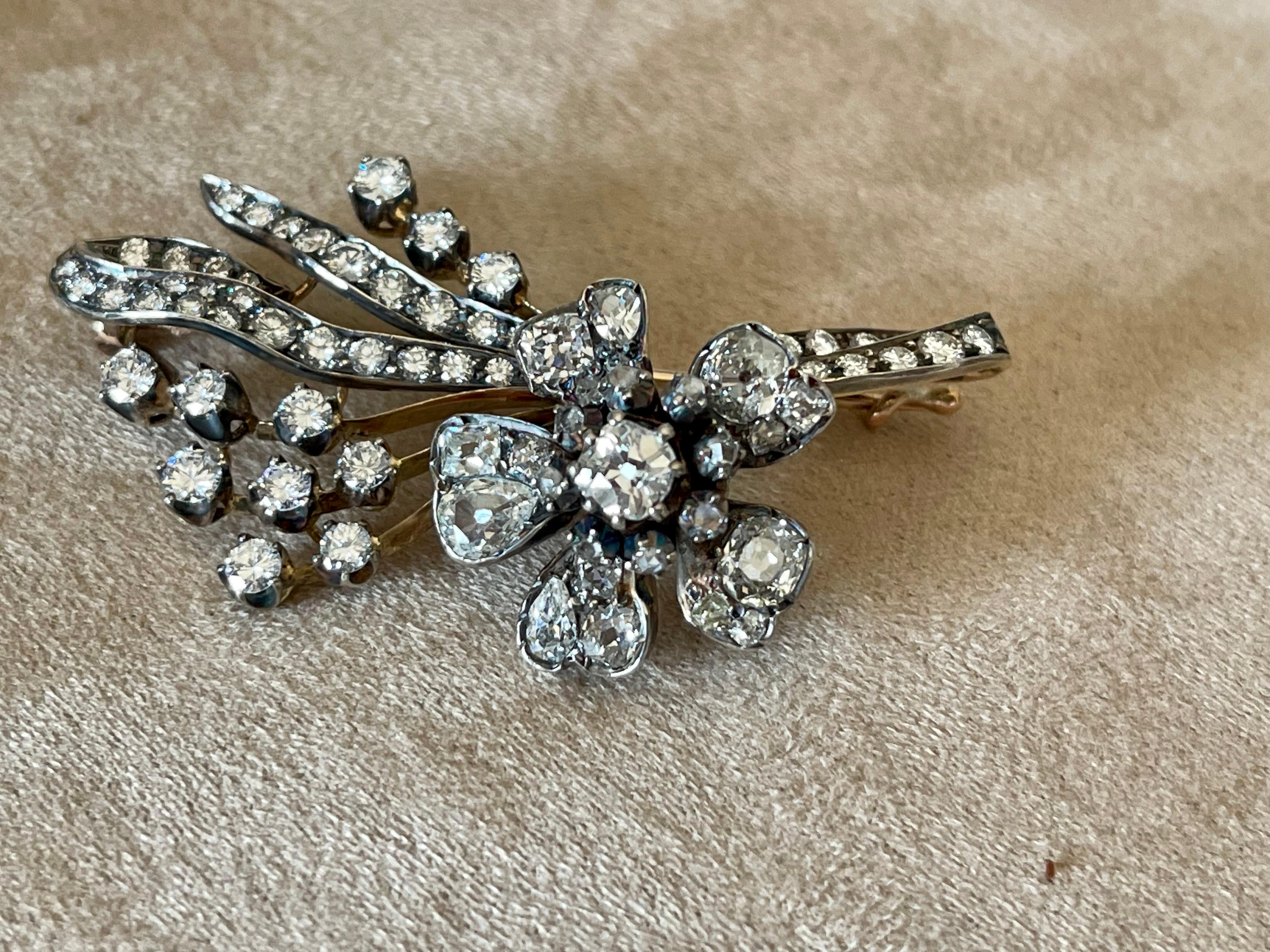 A Victorian diamond spray brooch, the flower-head centrally-set with an old-cut diamond estimated to weigh 0.50 carats, each petal pave-set with old mine-cut diamonds, set amongst diamond-set foliate decorations, the diamonds estimated to weigh