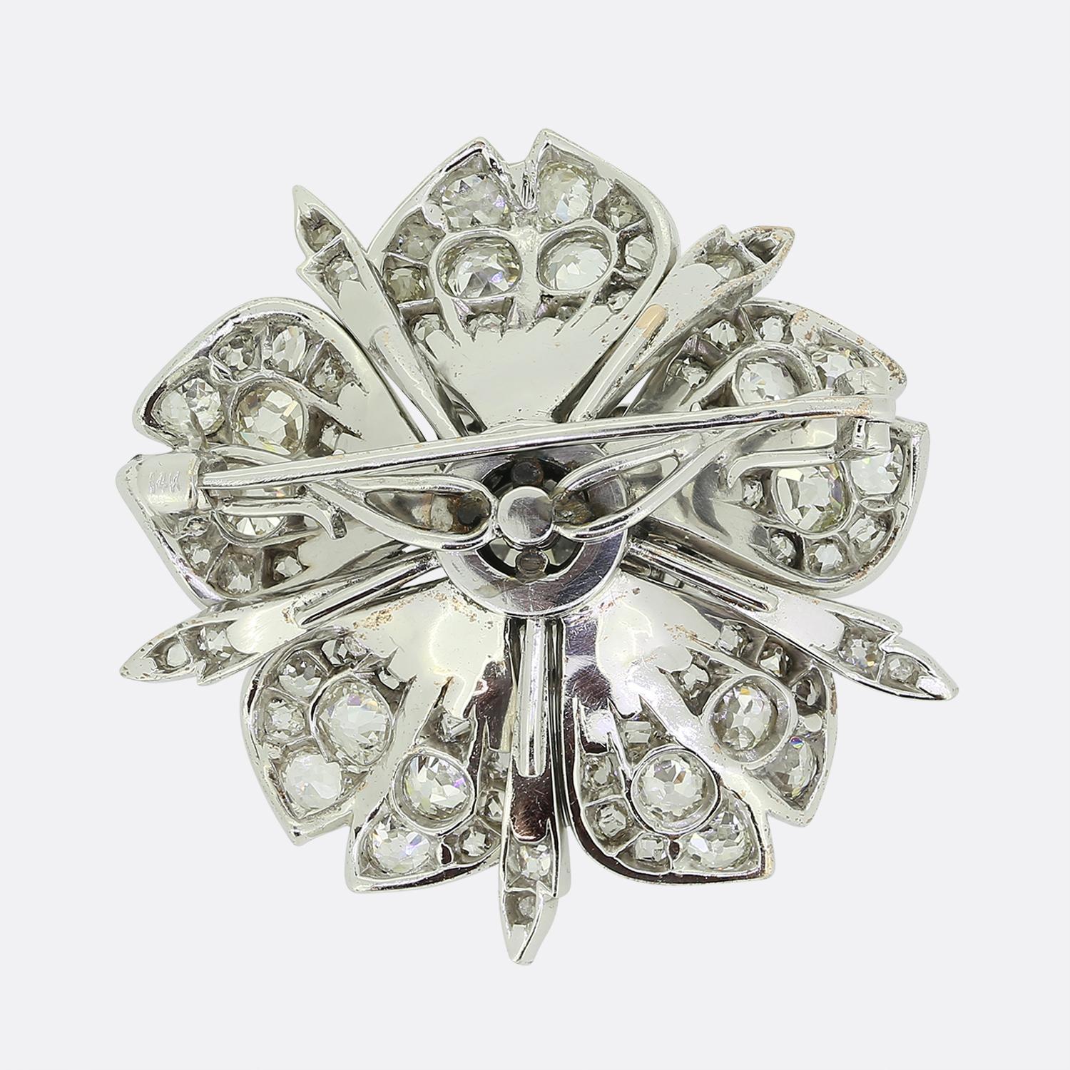 Here we have a beautiful diamond brooch crafted from 14ct white gold into the shape of a flower head. This antique piece features a collet-set old mine cut diamond at the centre which sits slightly risen whilst being contained by rose cut diamond