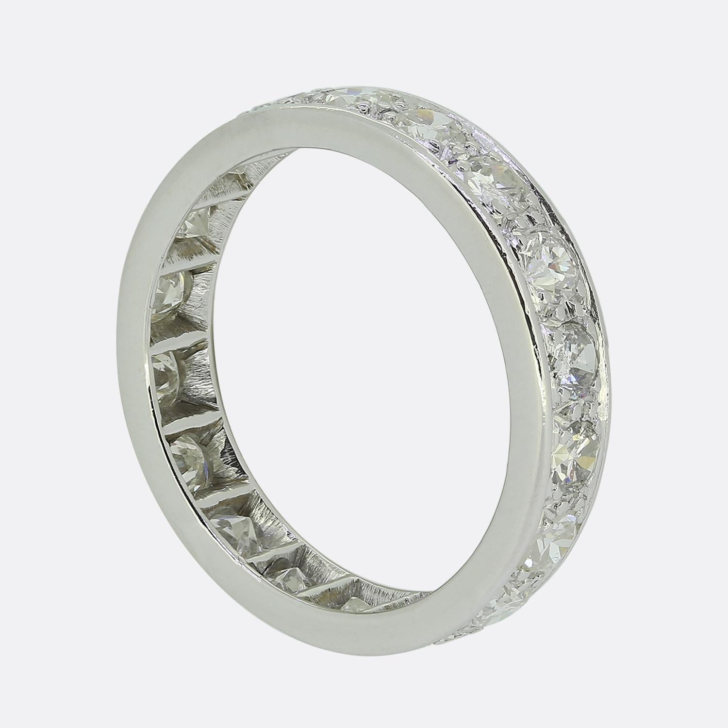 Nous avons ici une bague en platine de style classique avec une rangée continue de diamants ronds à facettes de taille européenne. Chaque diamant d'un blanc éclatant a été serti étroitement, créant un scintillement sans faille autour du doigt