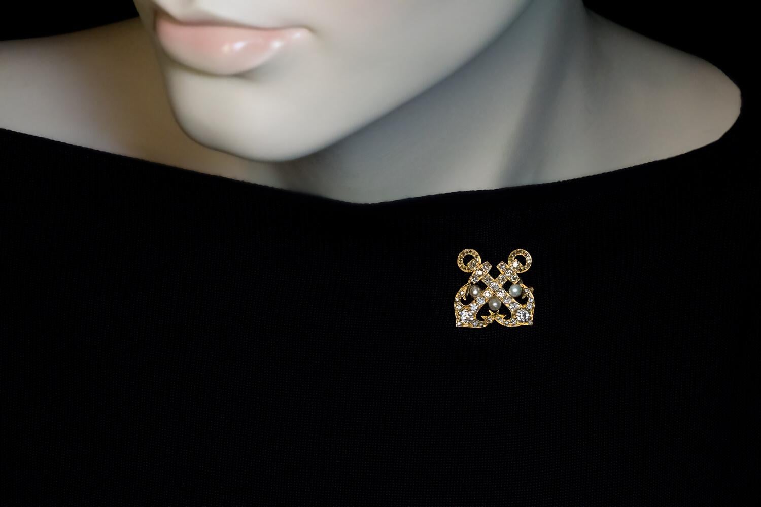 Circa 1890s

La broche/épingle en or jaune 14 carats est conçue comme deux ancres croisées qui sont embellies par des diamants de taille ancienne européenne, ancienne mine et rose, et sont rehaussées de trois perles.

Les ancres symbolisent l'amour