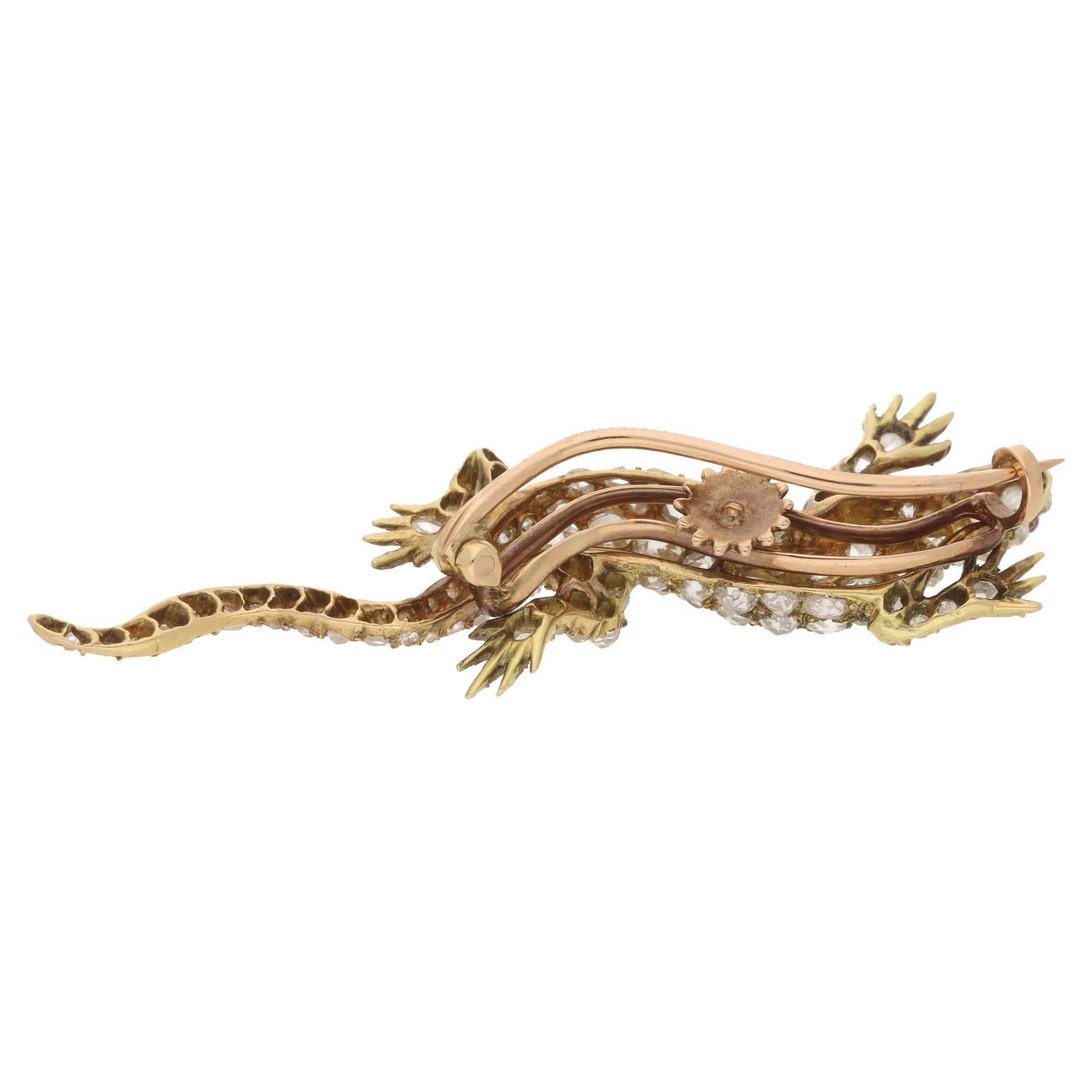 An exquisitely made 18ct gold antique diamond set lizard brooch, dating from 1880-1890. The body of the lizard is grain set with old mine and rose cut diamonds and its eyes are set with rubies. The brooch measures 6cm in length and 2cm in width.
