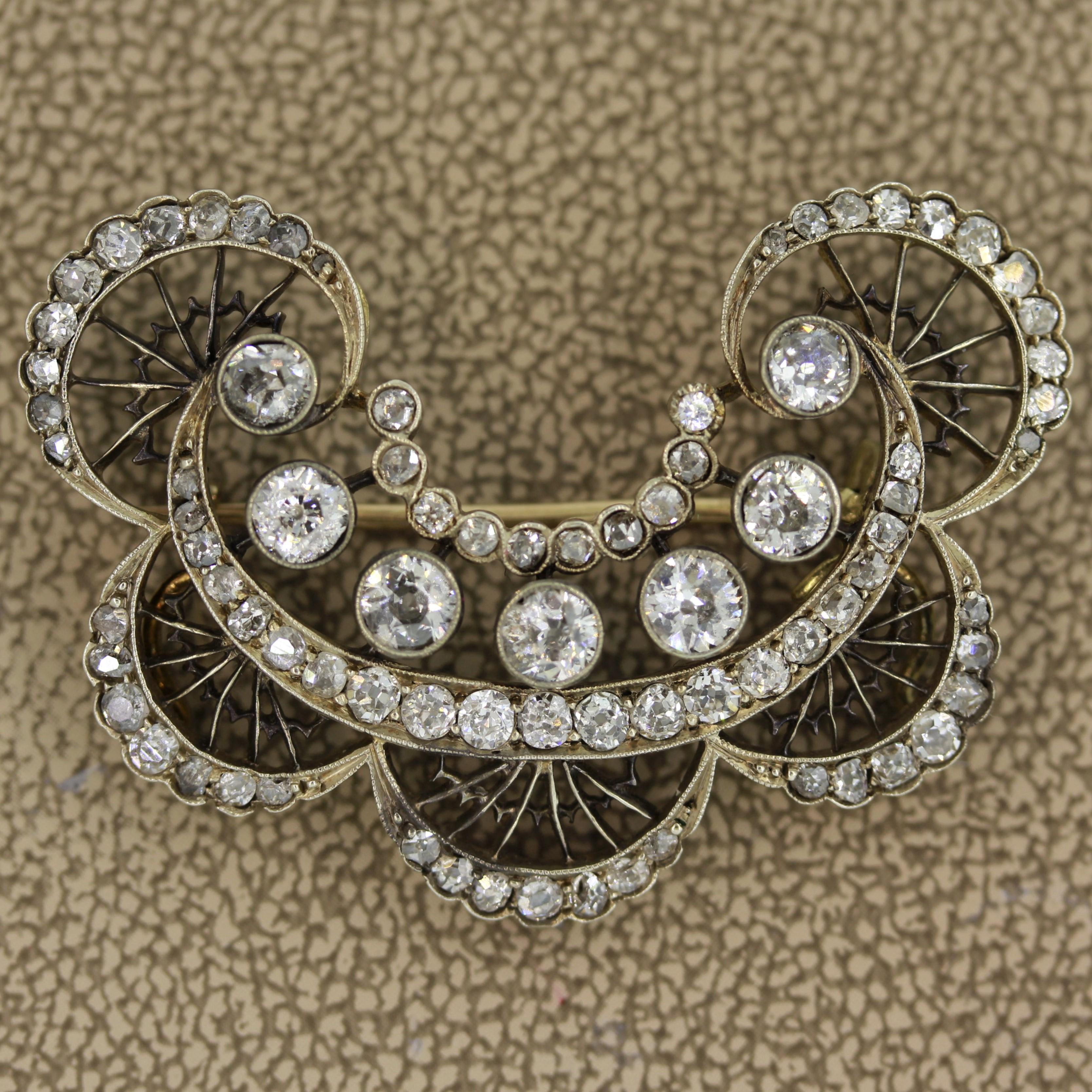 Circa 1895, this antique brooch from the late Victorian era features a total of approximately 2.35 carats of European cut diamonds. This piece was hand made in 14k yellow gold with a silver-topping to give it a white appearance. The pin is finished
