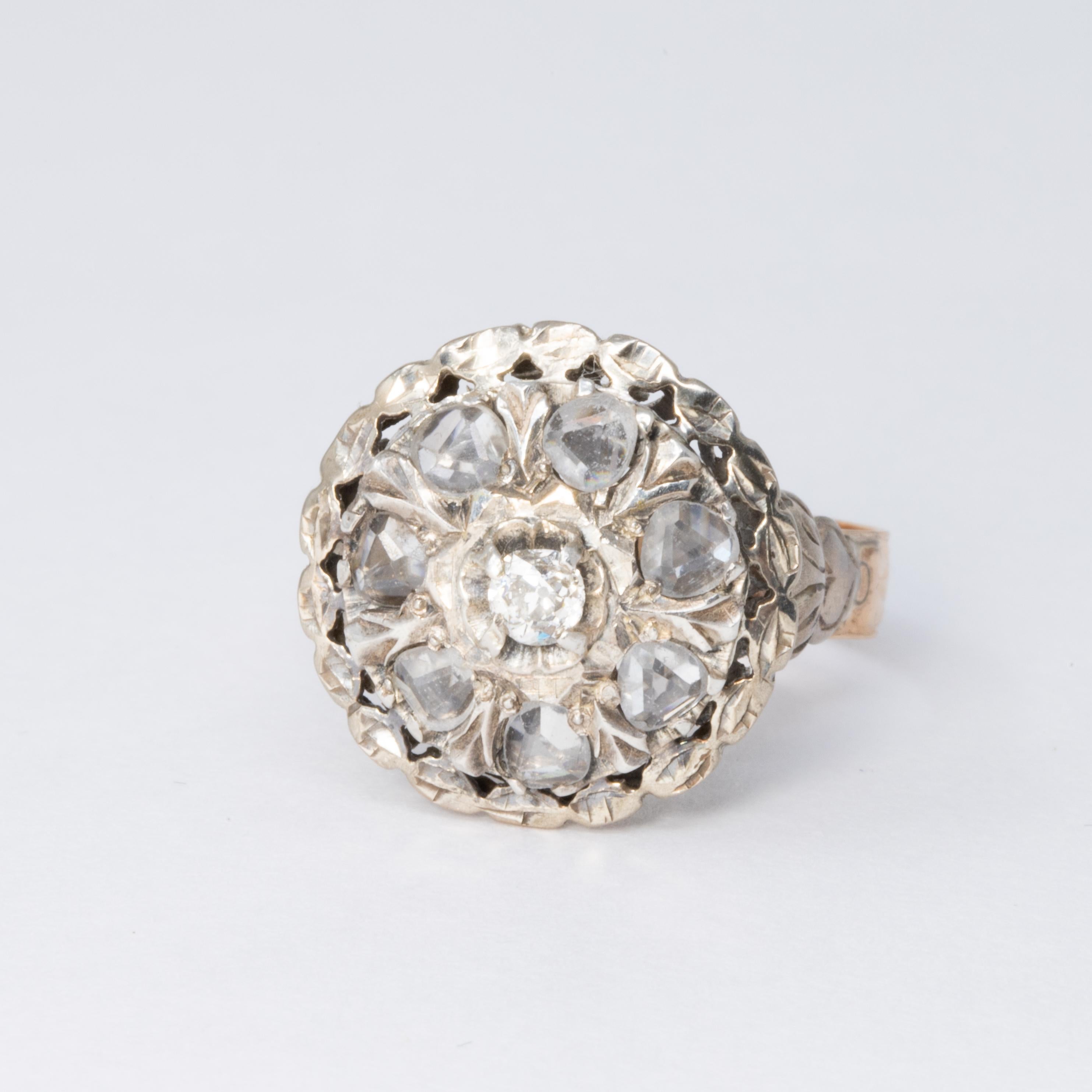 An exquisite antique ring, featuring an elevated halo-styled face design with a centerpiece 0.20 ct round diamond, surrounded with 7 flat-top, rose-cut quartz crystals. The setting is decorated with sophisticated, Victorian-style, accents.

10K gold