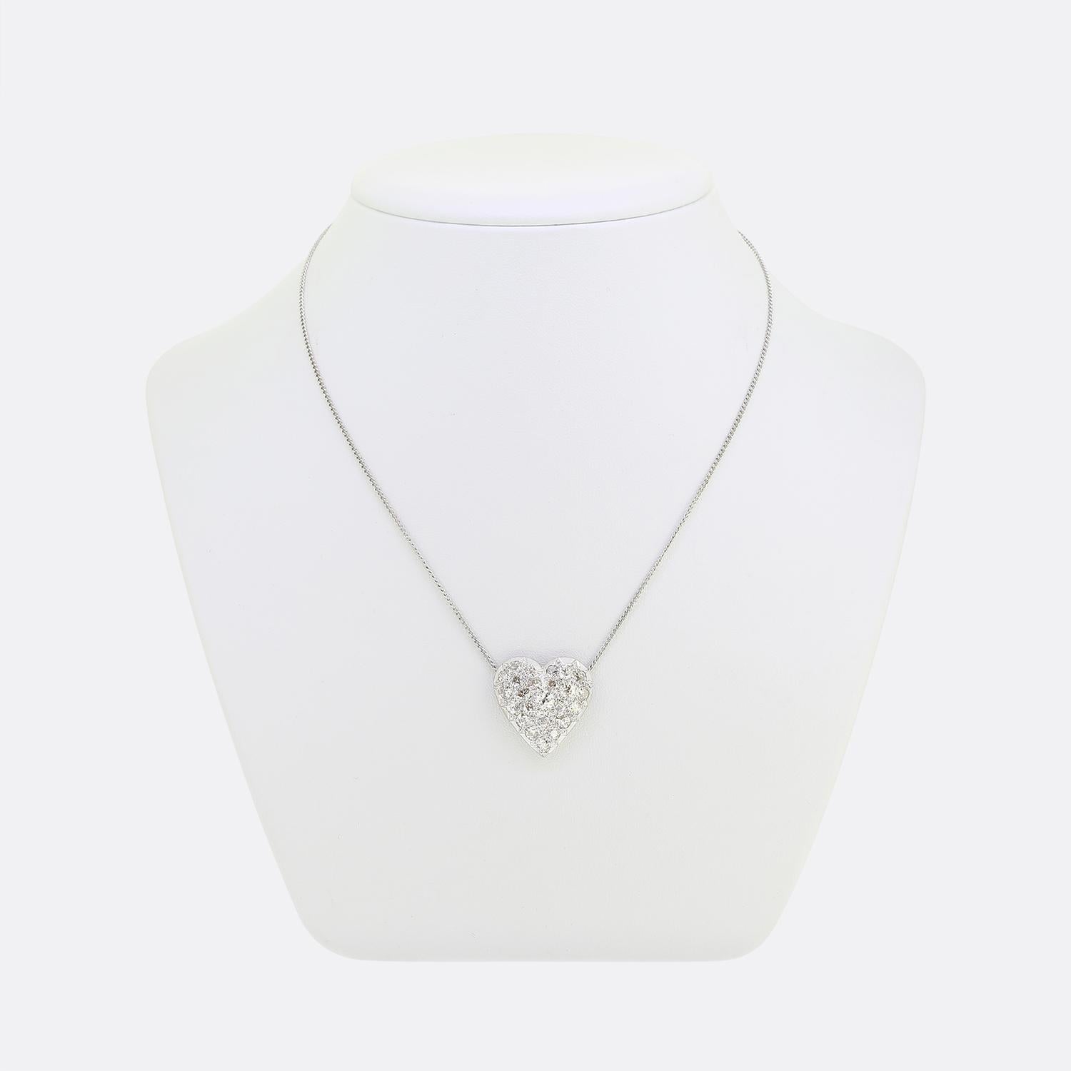 Here we have a charming diamond cluster necklace featuring a heart-shaped pendant. The pendant is crafted from 18ct white gold and adorned with a stunning array of round faceted old mine and old European cut diamonds, each radiating a brilliant