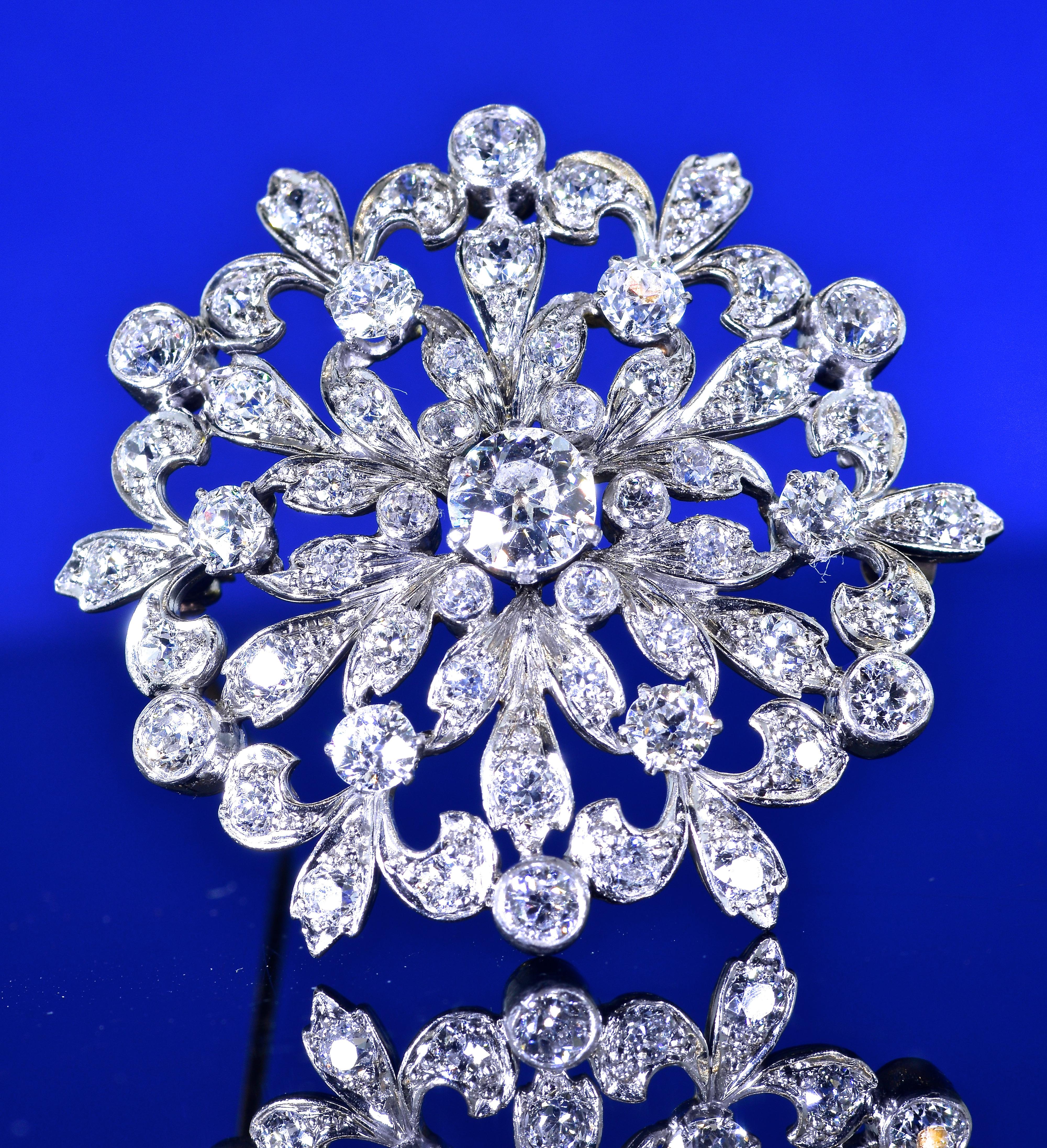 Antique Edwardian diamond pendant/brooch possessing fine white old cut diamonds.  This brooch or pendant is one of the better examples of a starburst brooch from this time period. There are 55 well matched European cut diamonds estimated to weigh