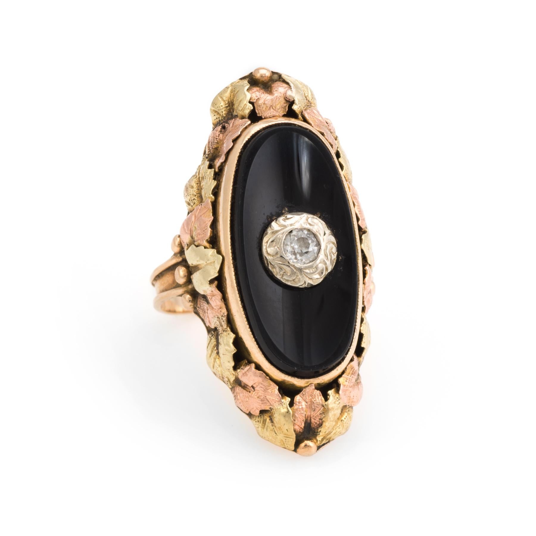 Finely detailed ring (circa 1920s to 1930s), crafted in 14 karat yellow gold. 

Centrally mounted estimated 0.06 carat old mine cut diamond (estimated at J-K color and I1 clarity). The onyx measures 19mm x 9.5mm.  

Distinct and elaborate rose and
