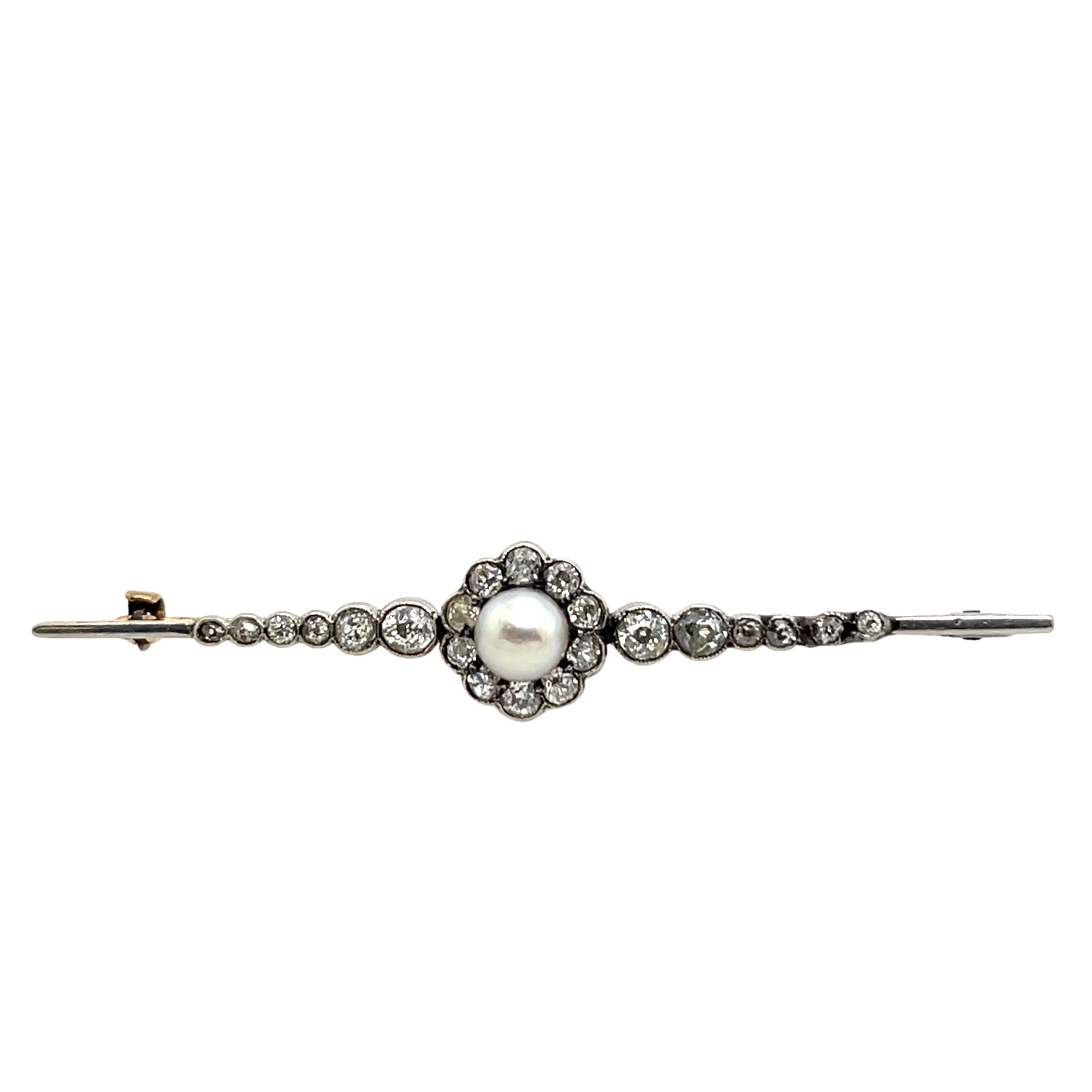 An exquisite antique brooch featuring a delicate blend of platinum and 12ct yellow gold, showcasing timeless craftsmanship. This elegant piece is adorned with shimmering diamonds and lustrous pearls, creating a sophisticated and classic design.