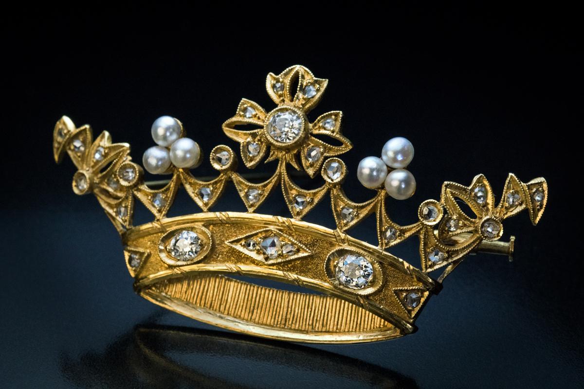 Etwa 1890er Jahre

Diese durchbrochene Goldbrosche aus der Belle Epoque ist fein modelliert wie eine königliche Krone, die mit Perlen, Diamanten im Altminen- und Rosenschliff verziert ist.

Die drei Hauptdiamanten sind strahlend weiße (Farbe E-F)