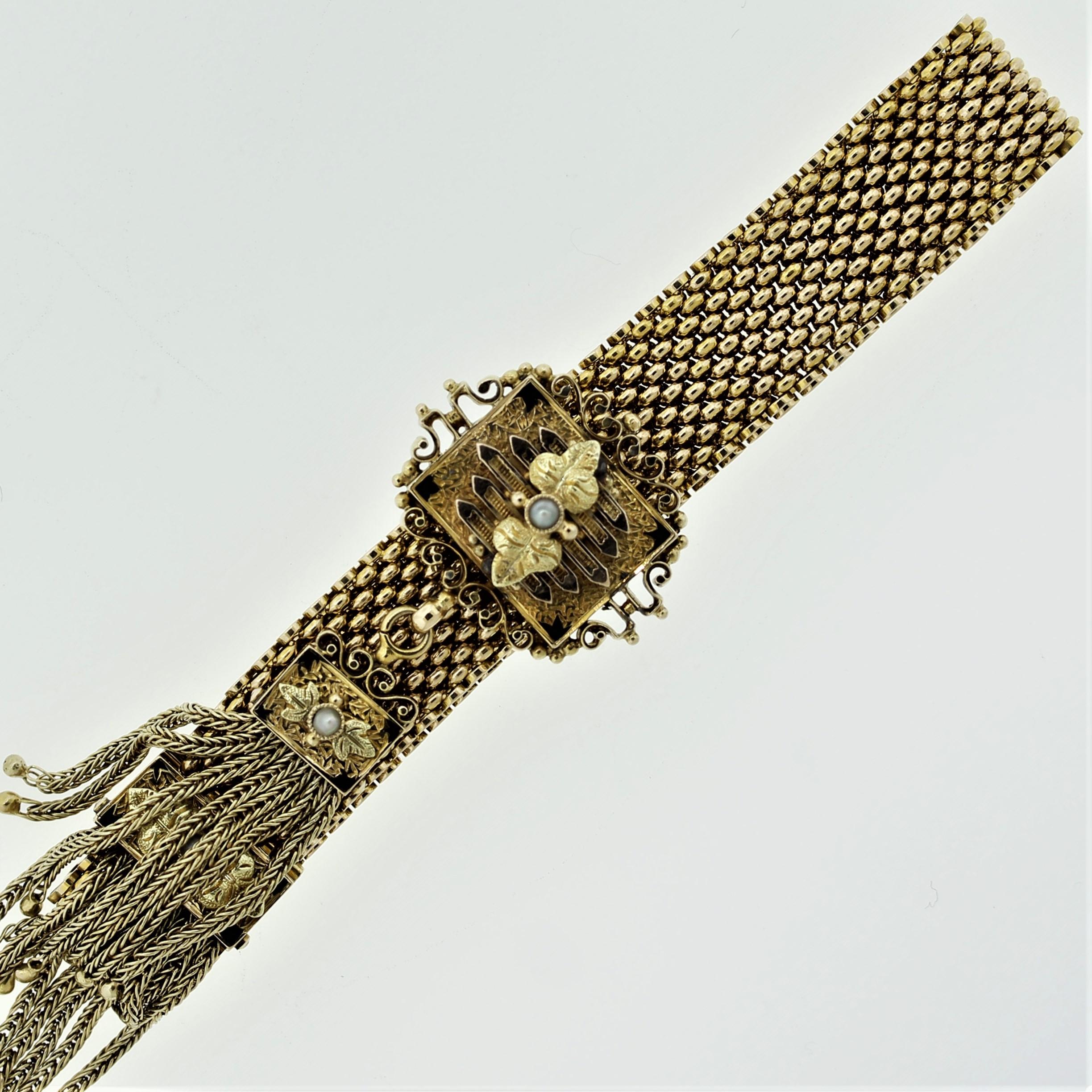 A beautiful antique bracelet, circa early 1900’s. It features fine hand-worked gold carvings on the slide as well as gold braided tassels on its ends. It is dotted with 3 natural pearls and accented with black enamel accents. Made in 14k yellow gold