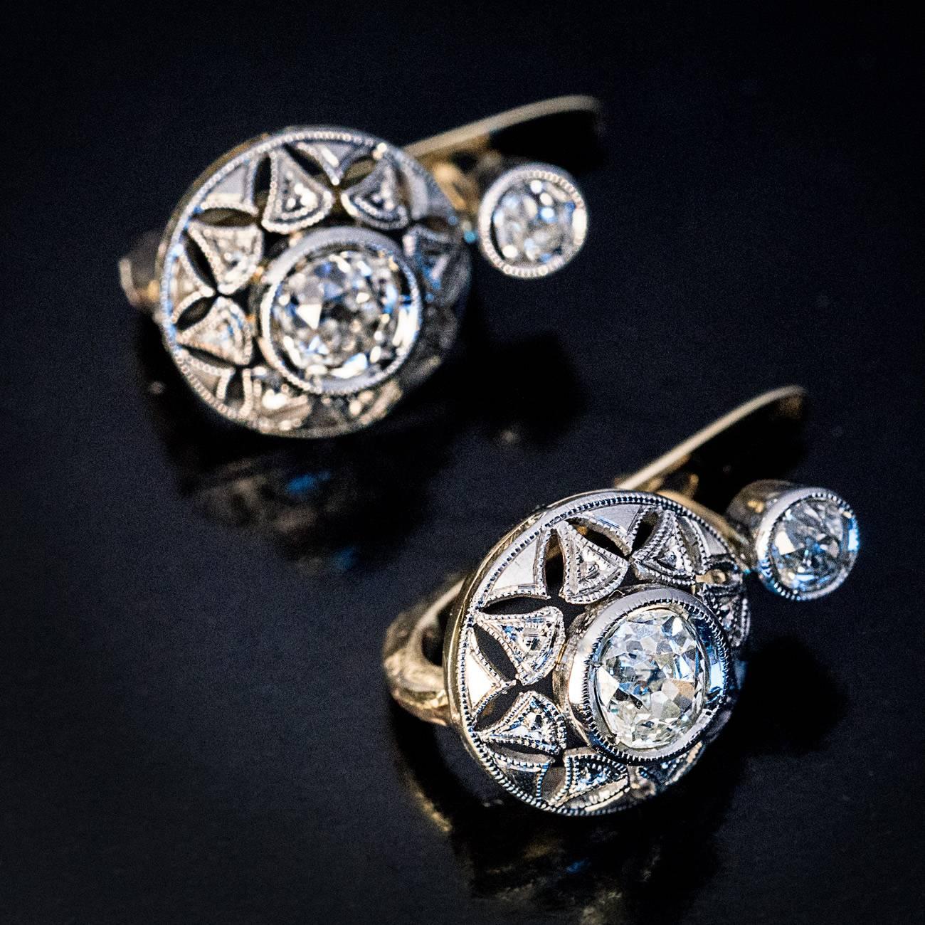 Early Art Deco, circa 1915

Antique platinum topped 18K gold earrings with an openwork star pattern are set to the centers with two old cushion cut diamonds: approximately 0.64 ct and 0.60 ct., I-J color, SI clarity., accented by two smaller old
