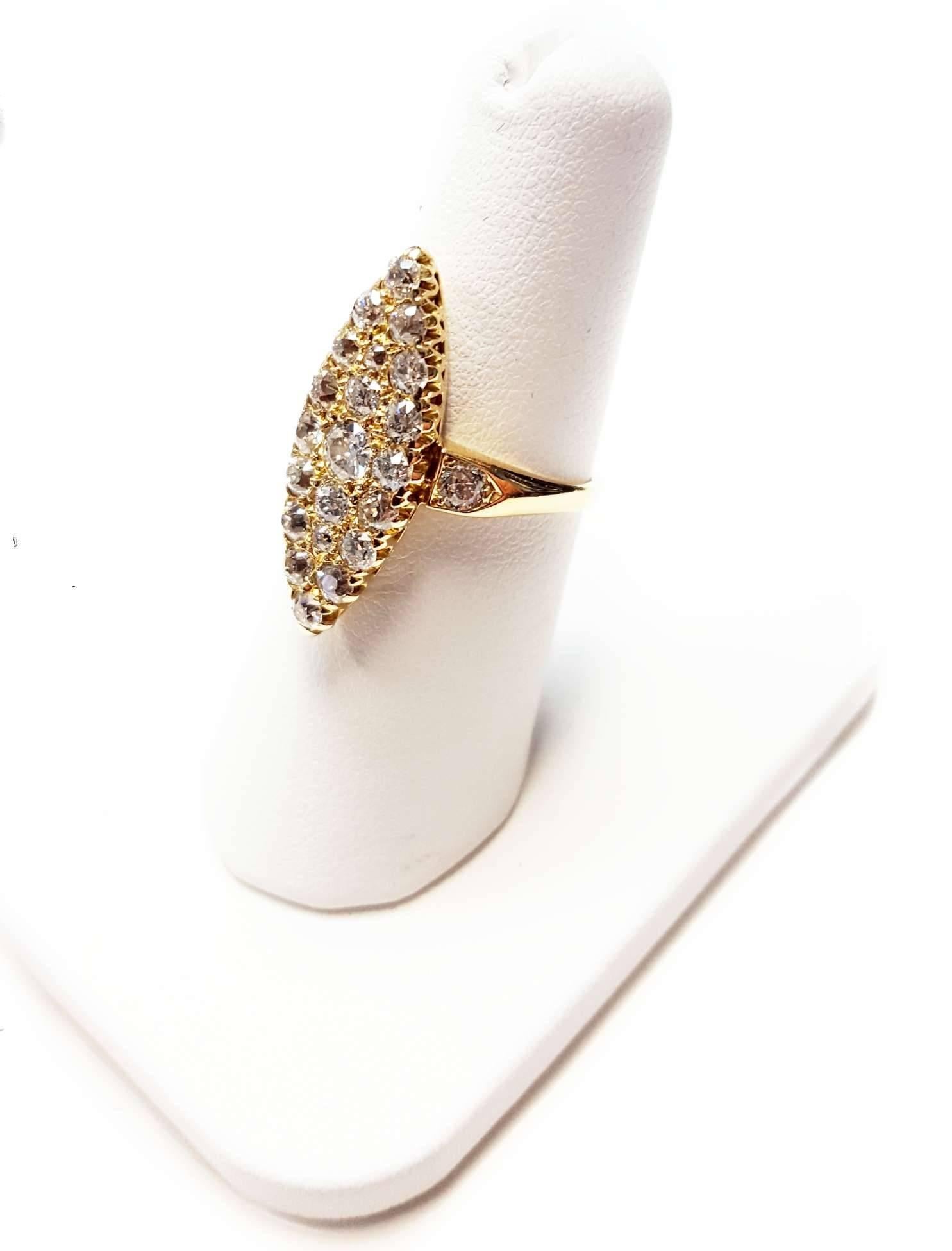An Early 1900's diamond ring set with 23 Old Mine Cut diamonds that weigh 1.40cttw. The ring measures 1 inch long and 3/8 inches wide. The diamonds are J to K color Vs2 to Si2 clarity. Set in 18 karat yellow gold. 