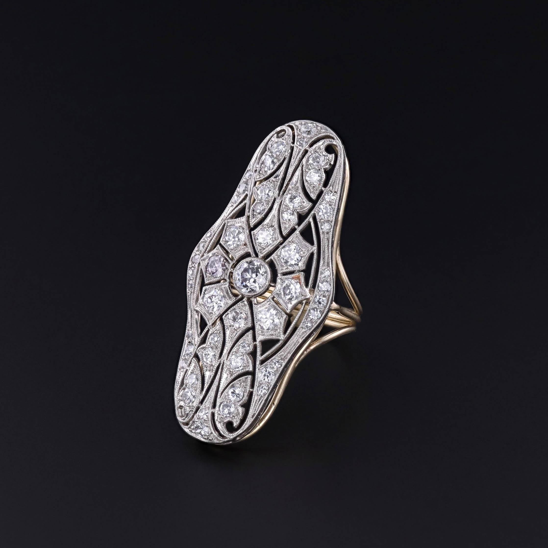 Antique Diamond Statement Ring: This exquisite antique diamond ring shimmers with an array of sparkling diamonds set in platinum. Originally a brooch (circa 1910), our skilled jeweler meticulously re-imagined it, removing the pin findings and