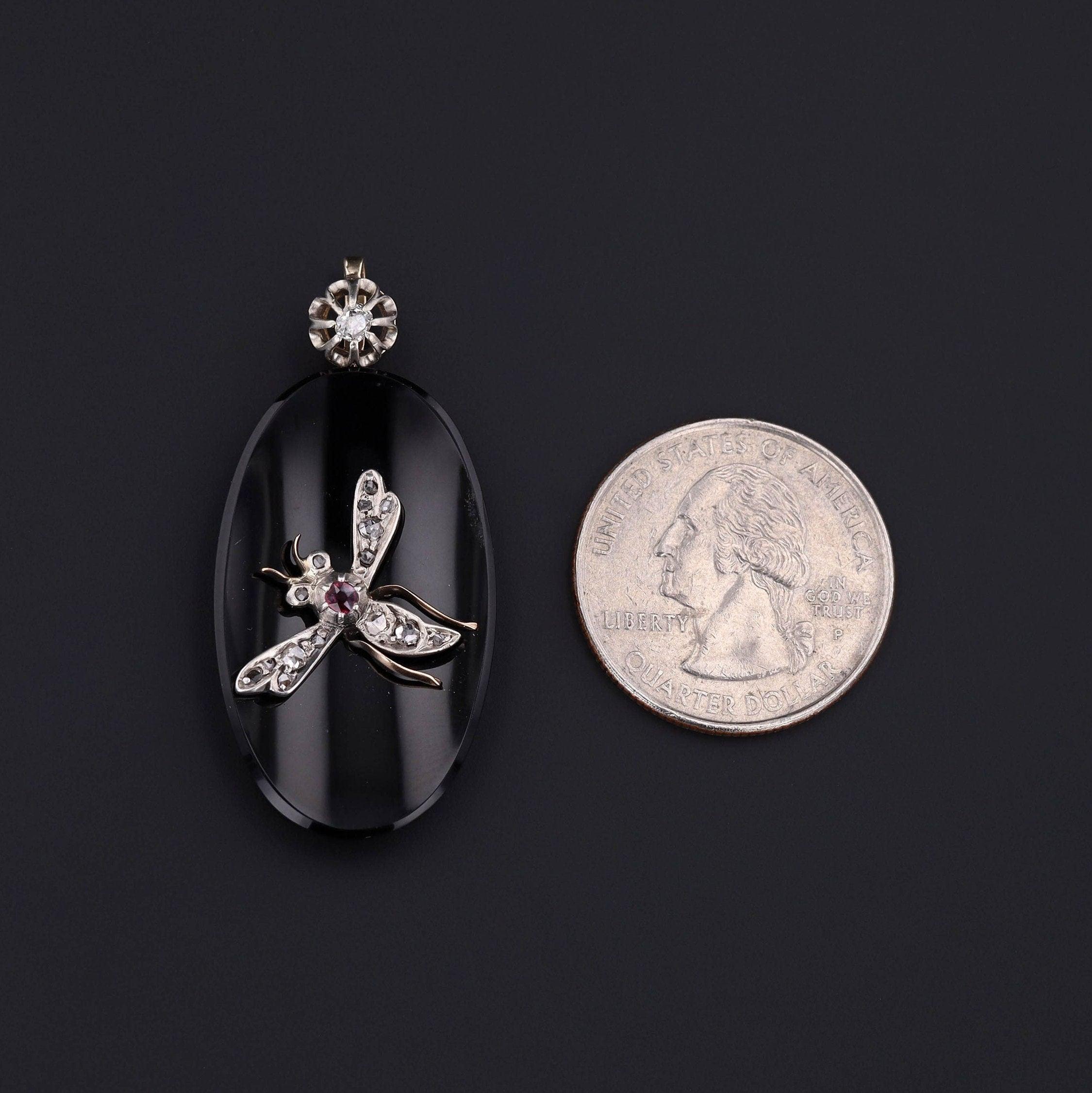Ce pendentif présente un insecte en platine, diamant et rubis au sommet d'un onyx ovale monté en or 14k. Le pendentif était à l'origine une broche ancienne (vers 1880-1900), tandis que le fermoir (également ancien) a été ajouté plus tard. L'attache