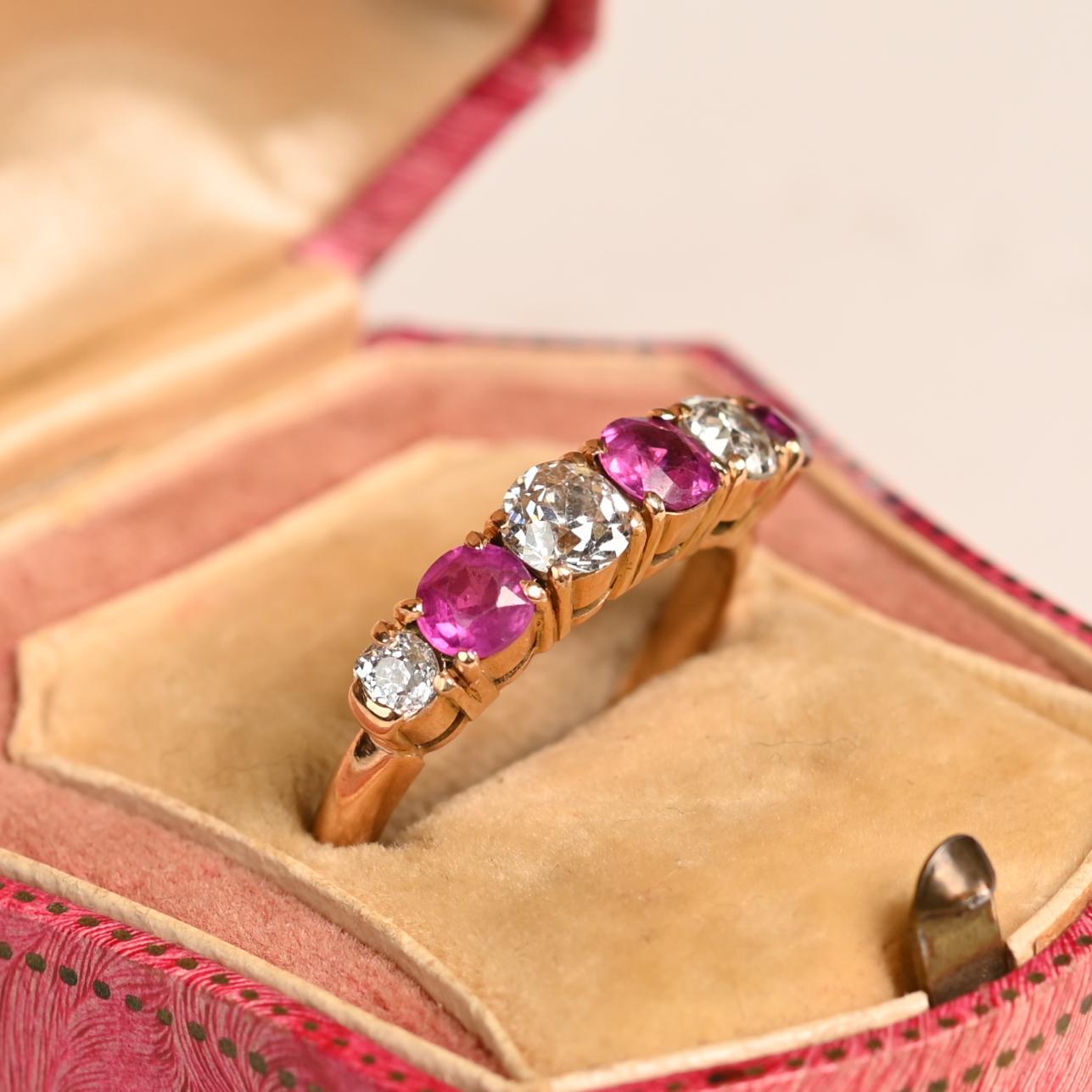 Questo squisito anello antico a sei pietre è uno splendido esempio di artigianato dell'epoca vittoriana, risalente al 1860 circa. Realizzato a mano in ricco oro giallo 18 carati, presenta un'armoniosa disposizione di tre diamanti taglio vecchio