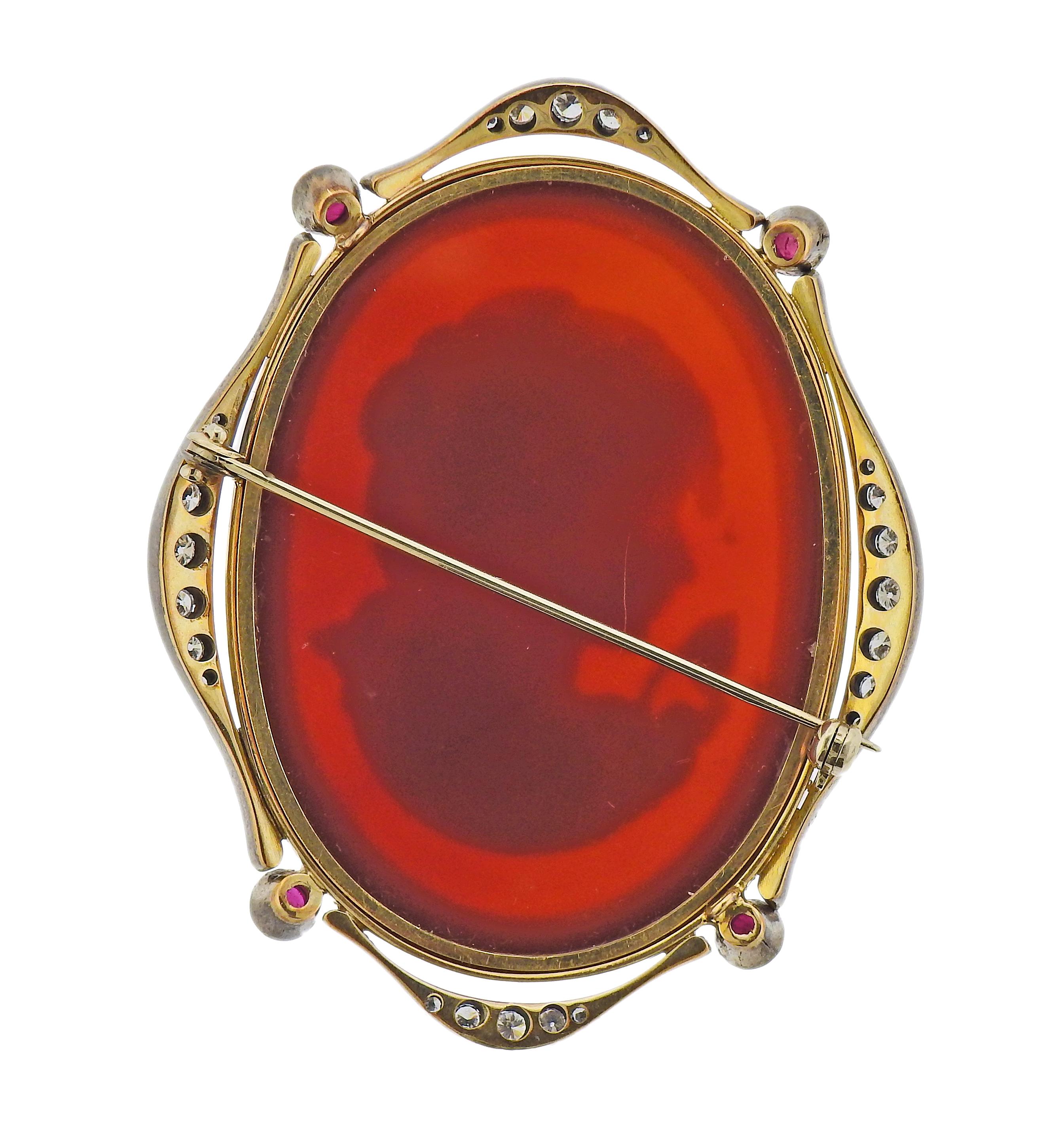 18k gold antique brooch, featuring hardstone cameo, surrounded with 4 rubies and approx. 0.30ctw in diamonds. Brooch is 62mm x 50mm. Tested 18k. Weight - 27.6 grams. 