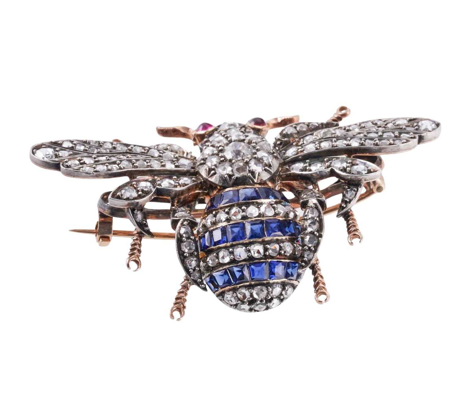 Antique 14k gold and silver bee brooch, adorned with ruby eyes, blue sapphires and rose cut diamonds. The brooch measures 1 3/8