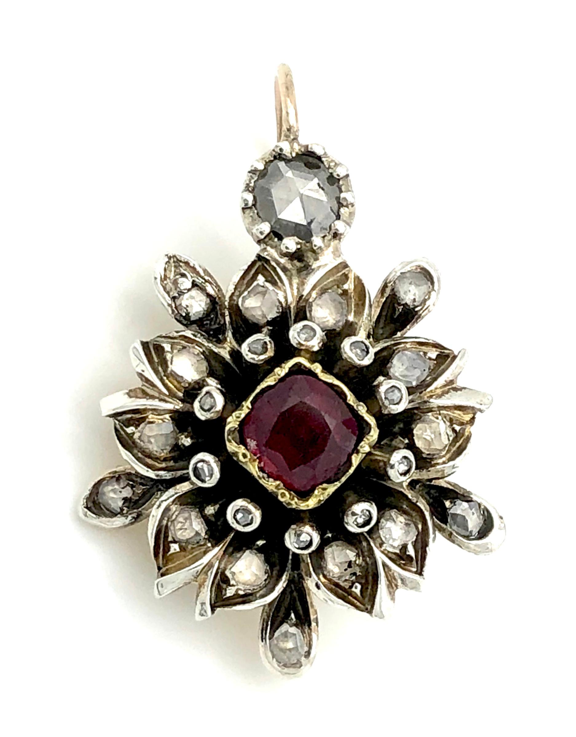 Antique silver gold-backed earrings in the shape of flowers are set with one large old cut old mine diamond. Small diamonds decorate the leaves. The hooks are 14 karat gold. One large square-cut deep red ruby is set in each flower centre. The rubies