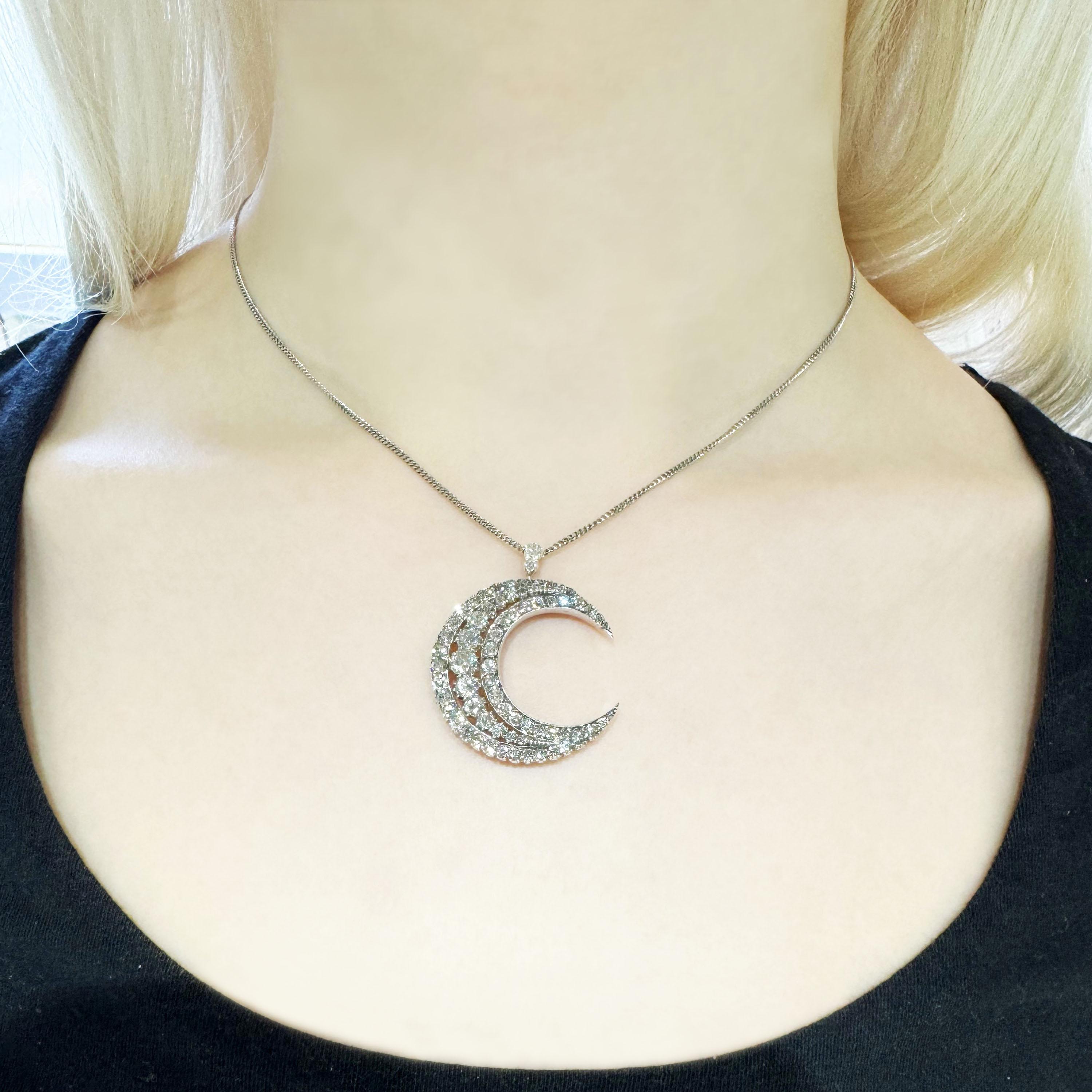 An antique diamond crescent pendant, set with a row of old-cut diamonds, graduating from the centre, in cut down settings, surrounded by old-cut diamonds, in a grain set channel, with a flat edge on the inside and grain and cut down settings, with a