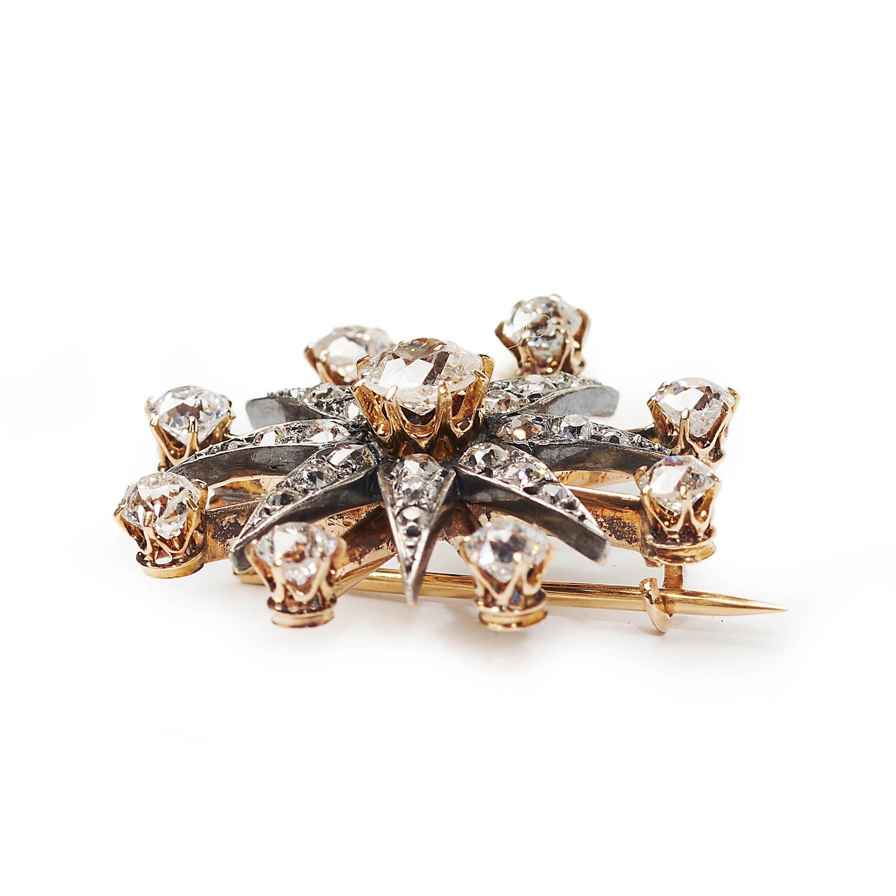 An antique, diamond star brooch, with a raised, old-cut diamond, in a gold claw setting, in the centre of an eight pointed silver star, each ray set with three, graduating, old-cut diamonds, in grain settings, with single diamond rays, in crown claw