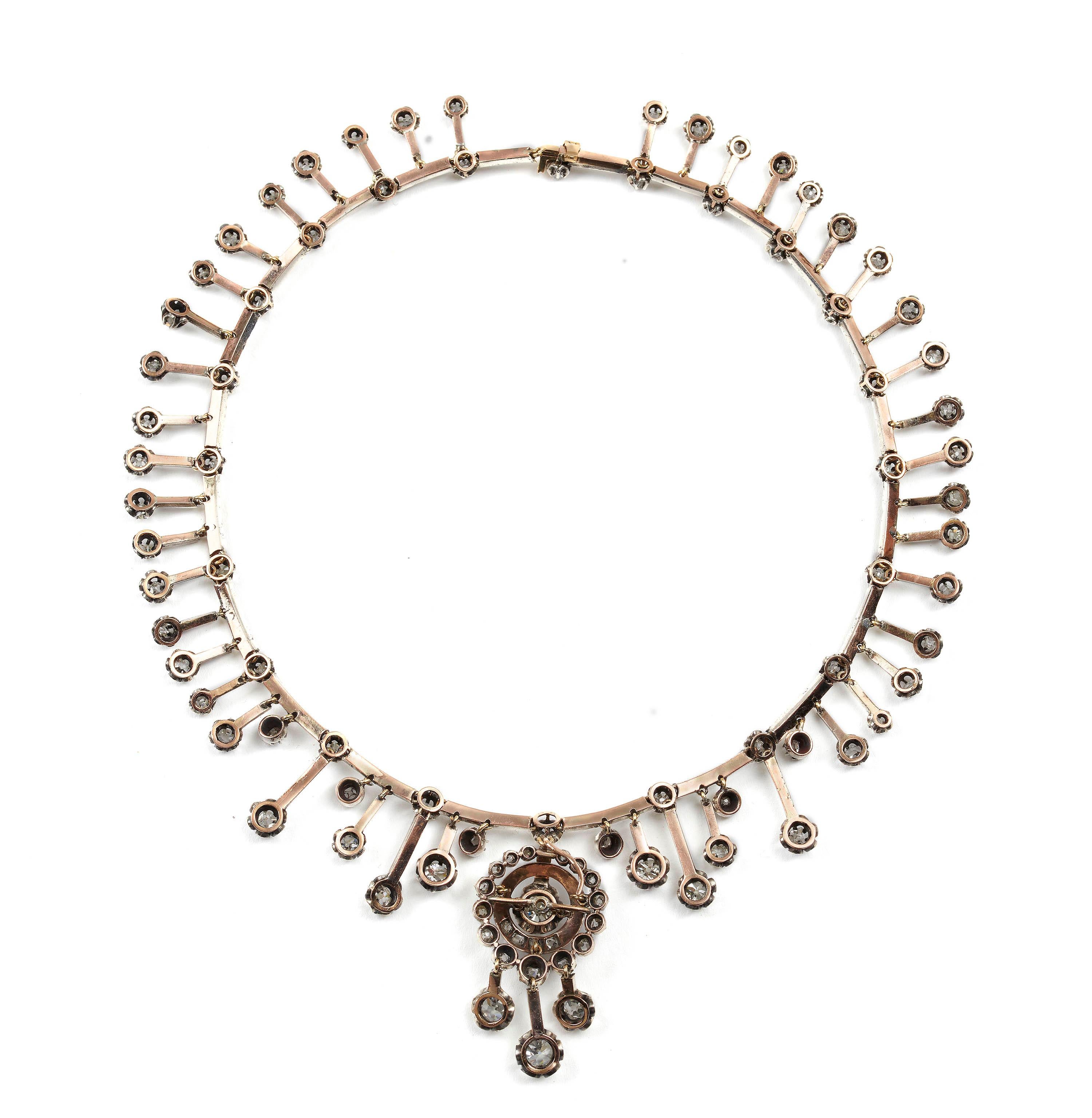 A French antique Fraumont diamond necklace and earring suite, with a drop pendant, set with an old-cut diamond, in a claw setting, surrounded by a circle of grain set diamonds and a border of graduated old-cut diamonds, with three suspended old-cut