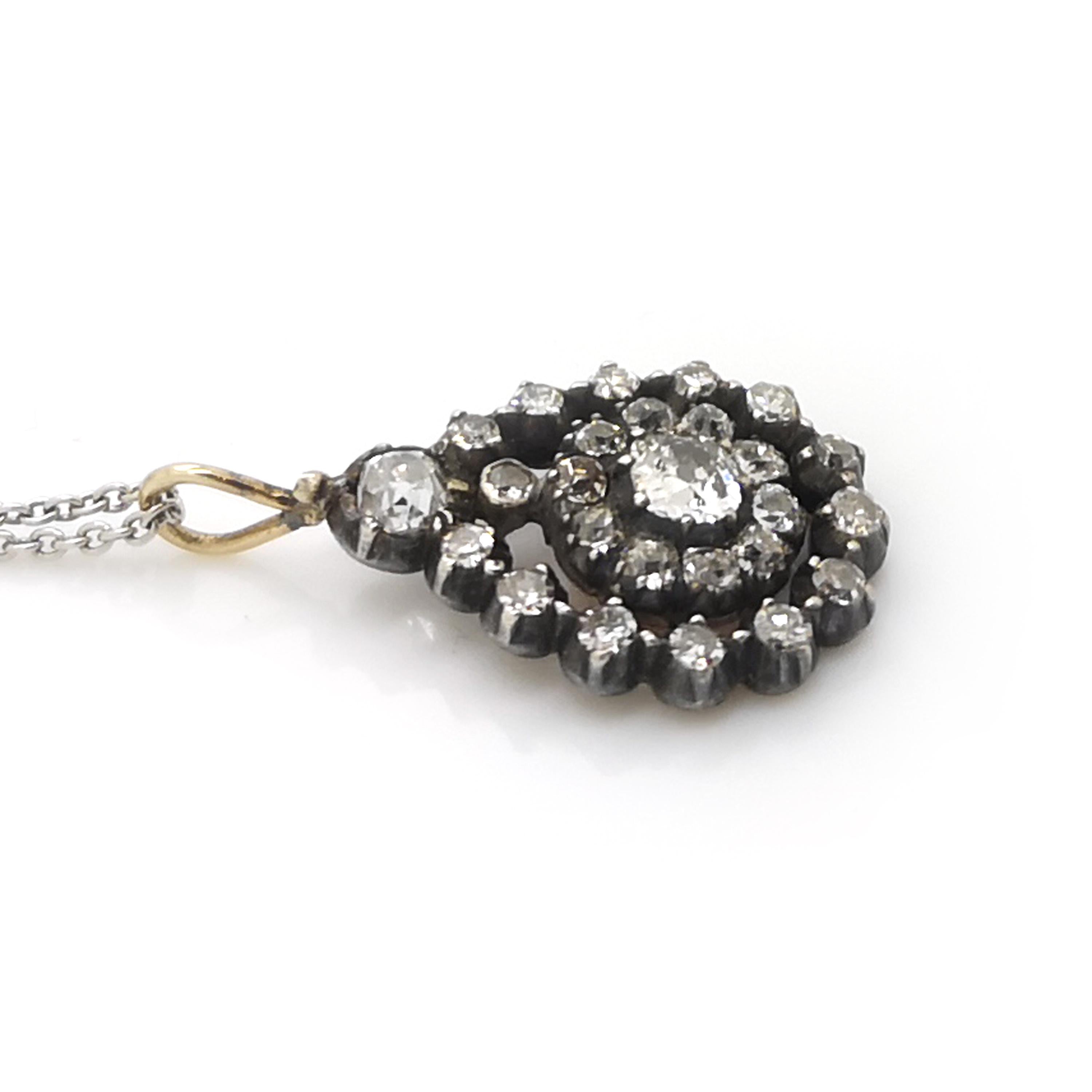 A Victorian diamond drop pendant, with an old-cut, diamond set, open pear shape loop, with a central diamond cluster suspended in the centre, set with old-cut diamonds, in cut down settings, mounted in silver-upon-gold, circa 1880, on a modern