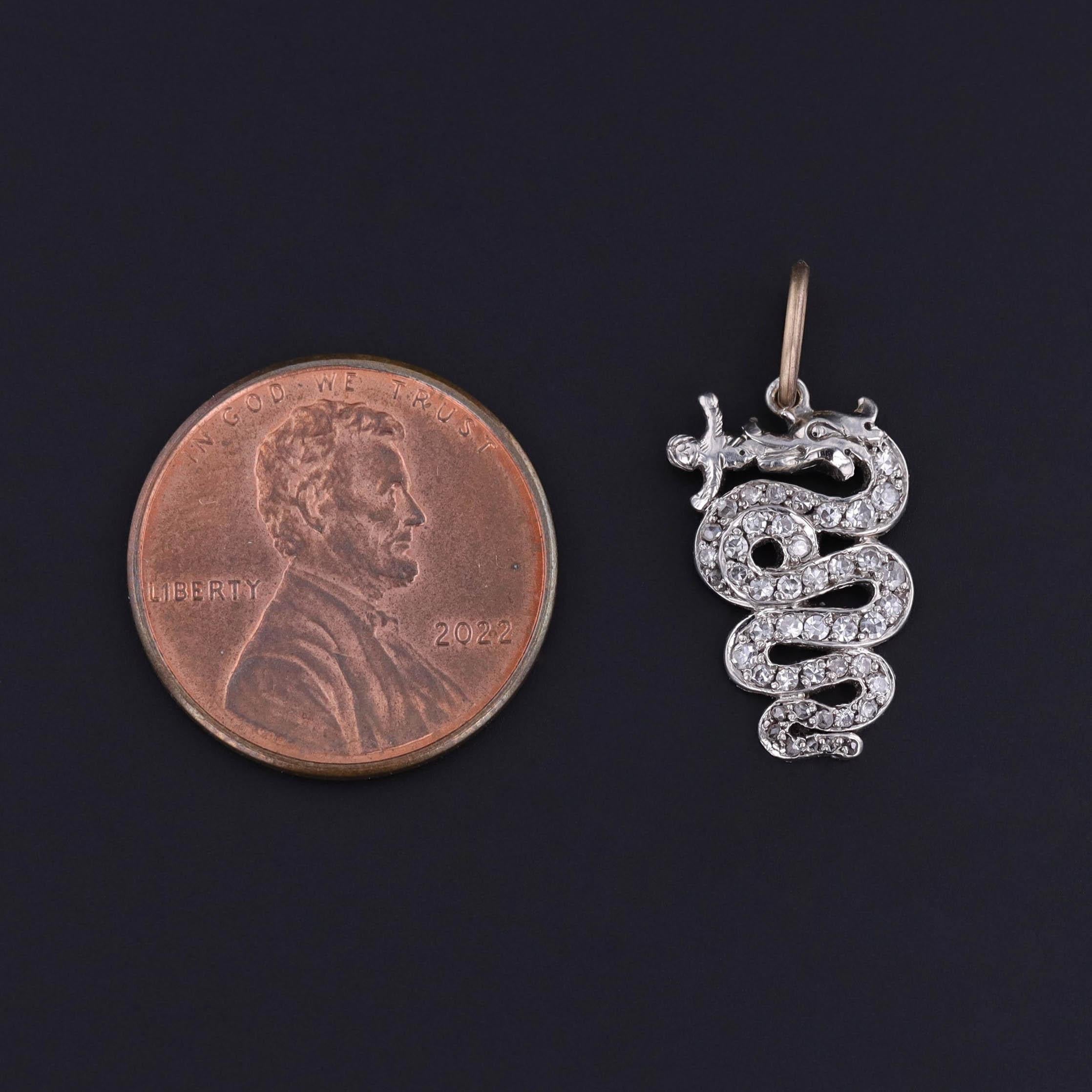 A rare and evocative treasure from the Edwardian era (circa 1900–1910), this finely crafted charm depicts a sinuous platinum serpent consuming a human figure — an arresting and symbolic design that speaks to themes of power, transformation, and