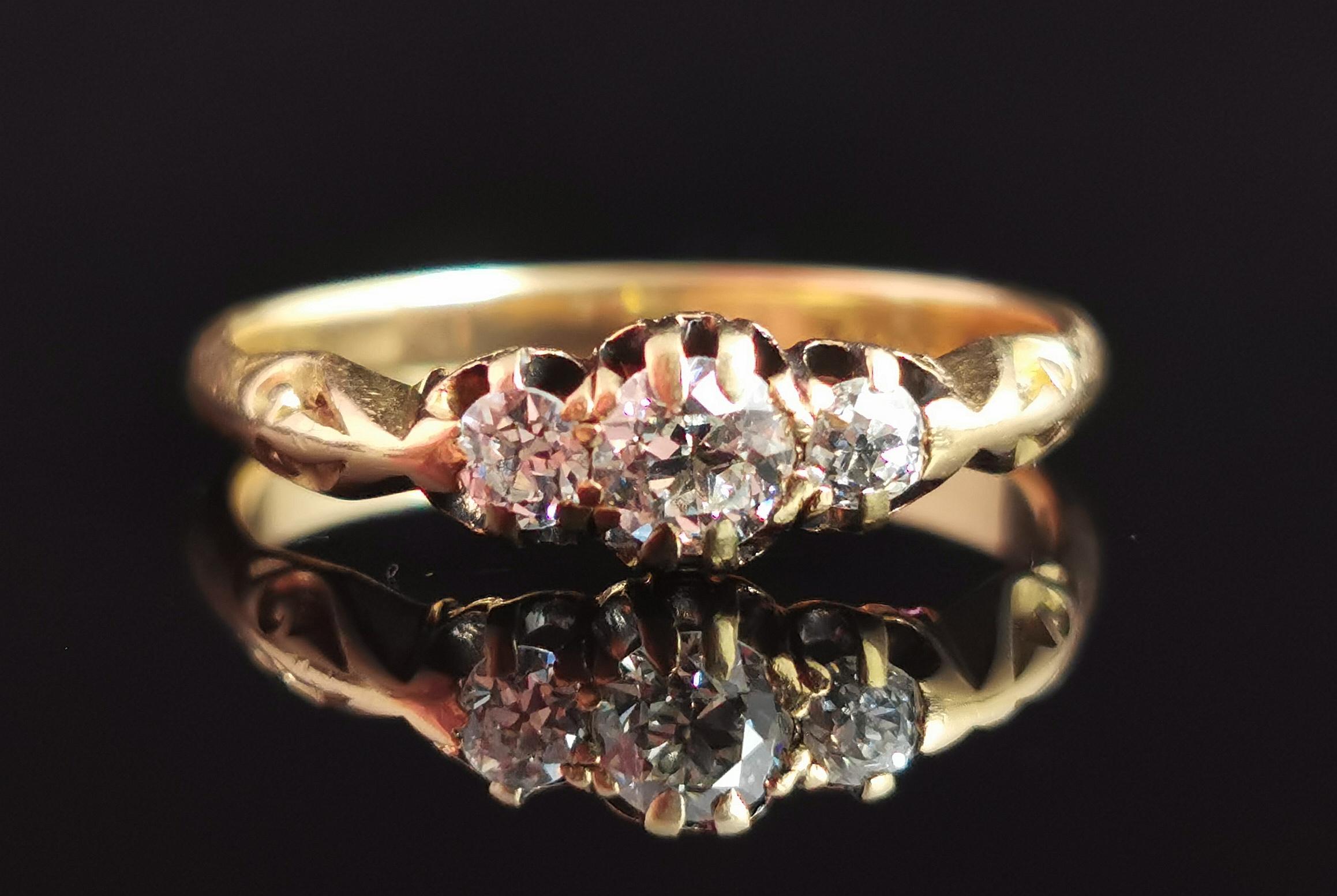 A beautiful antique 18kt gold and diamond three stone ring.

Smooth and rich 18kt yellow gold band with decorative engraved detailing to the shoulders.

Set with three single sparkling old cut diamonds with sparkle that twinkles in the light, they
