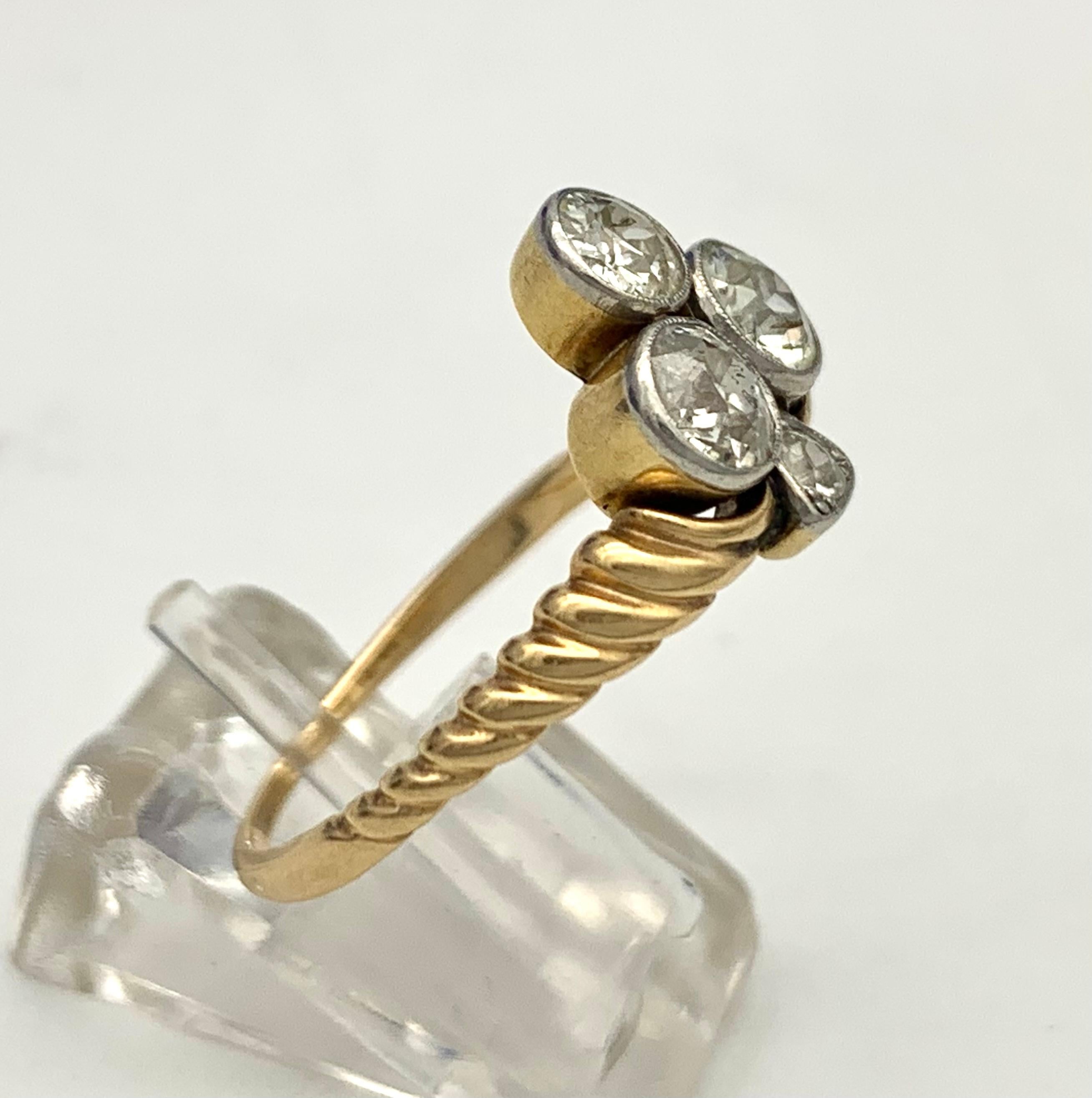 This elegant ring was made towards the end of the 19th century in Austria.
The trefoil consists out of three larger and one smaller diamond.
Three round diamonds are mounted in platinum millegrain settings backed onto 14K yellow gold. The gold ring