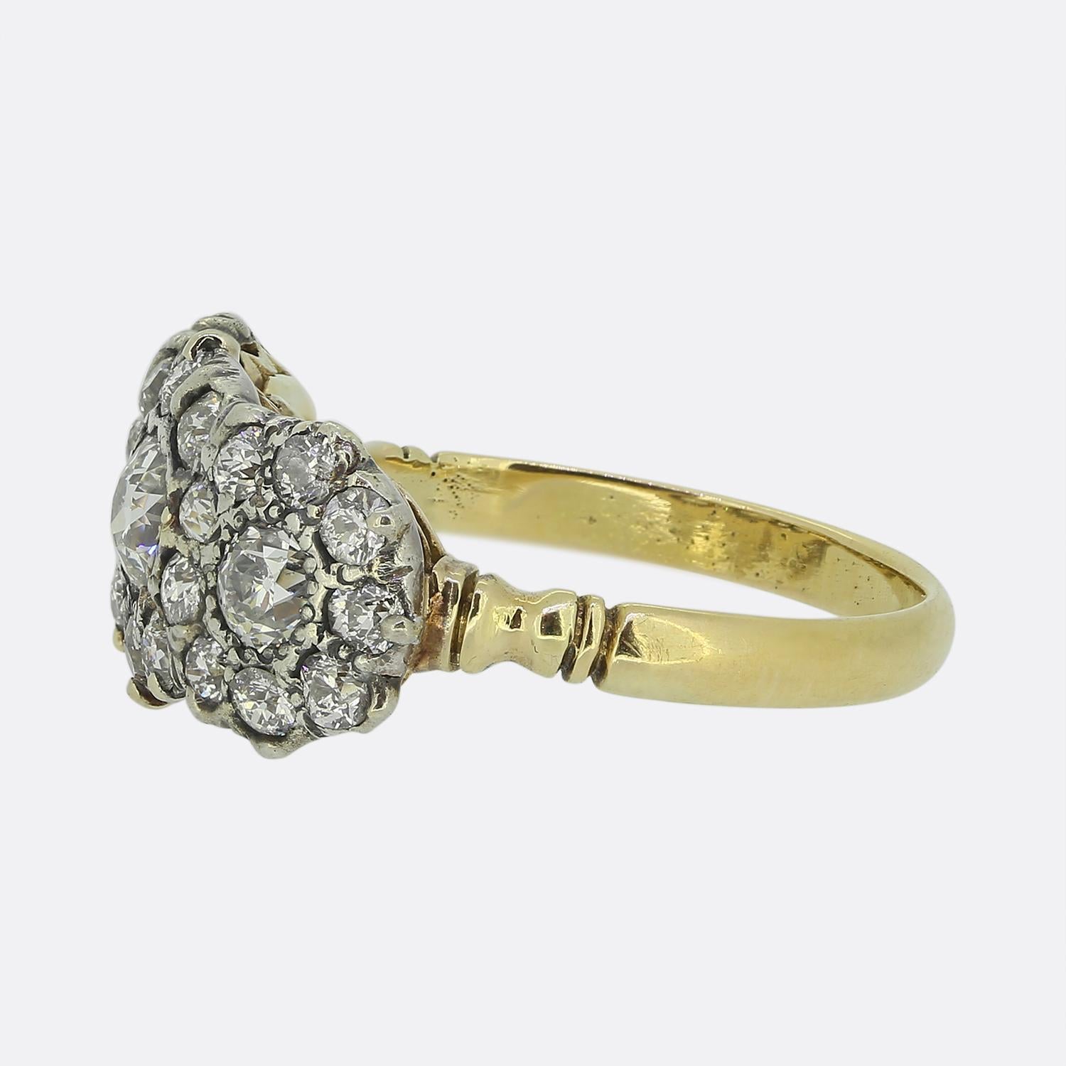 Qui abbiamo un bellissimo anello a triplo grappolo che mette in mostra un'incredibile serie di diamanti tagliati da vecchie miniere, ognuno dei quali emana un'accattivante tonalità bianca. Intorno a queste pietre centrali ci sono singole cornici di