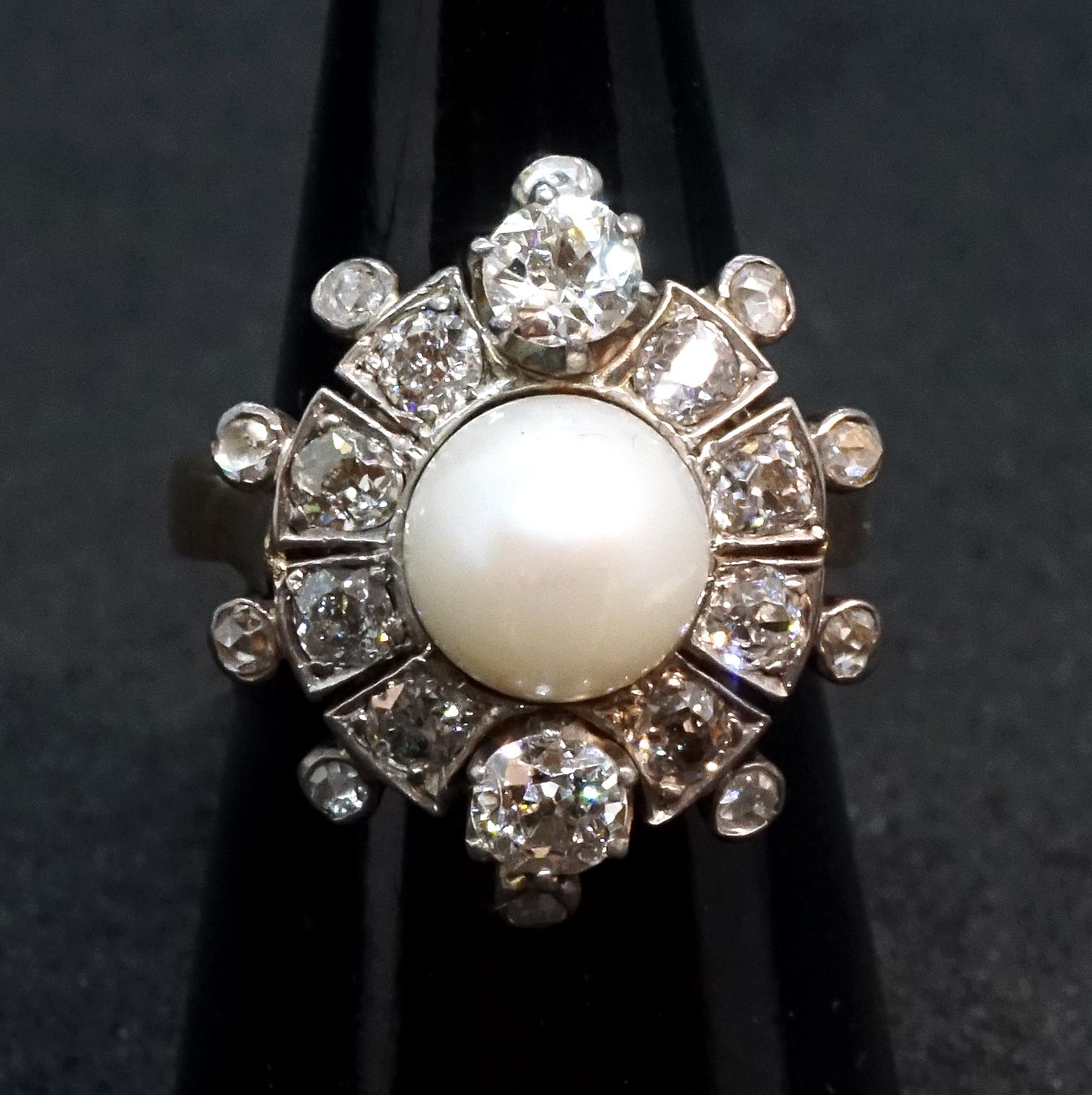 Antiker blumenförmiger alter Brillantring mit einer Perle in der Mitte:
zwei alte Diamanten im Brillantschliff auf einer Linie mit einer 0,7 cm großen Perle, deren Gewicht auf je 0,25 ct geschätzt wird (insgesamt 0,5 ct), dazwischen weitere acht