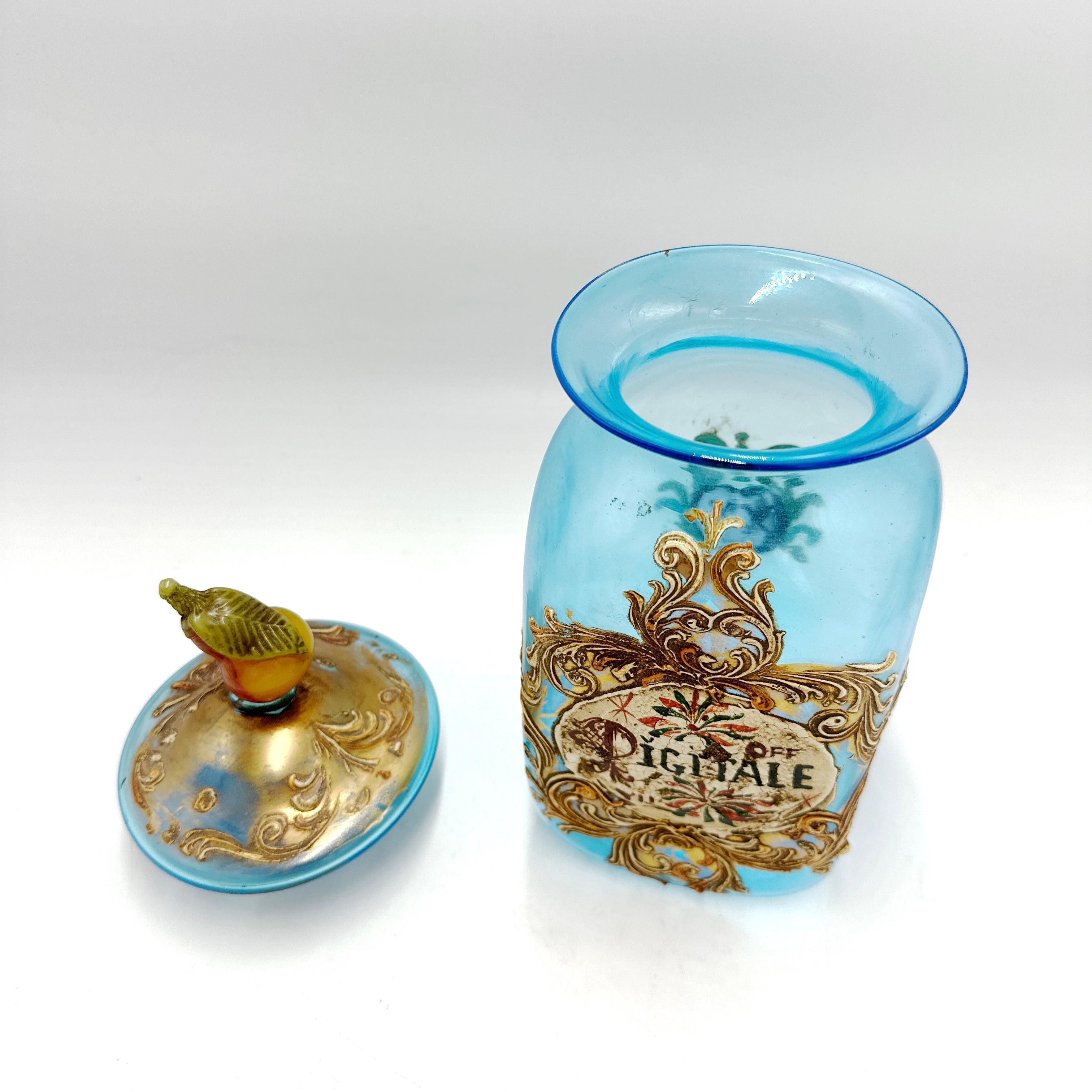 He aquí un precioso Botiquín de farmacia italiano antiguo de cristal de Murano. Elaboradamente pintado a mano y dorado sobre cristal de Murano azul. Con una pera con hoja en la tapa. Dice 