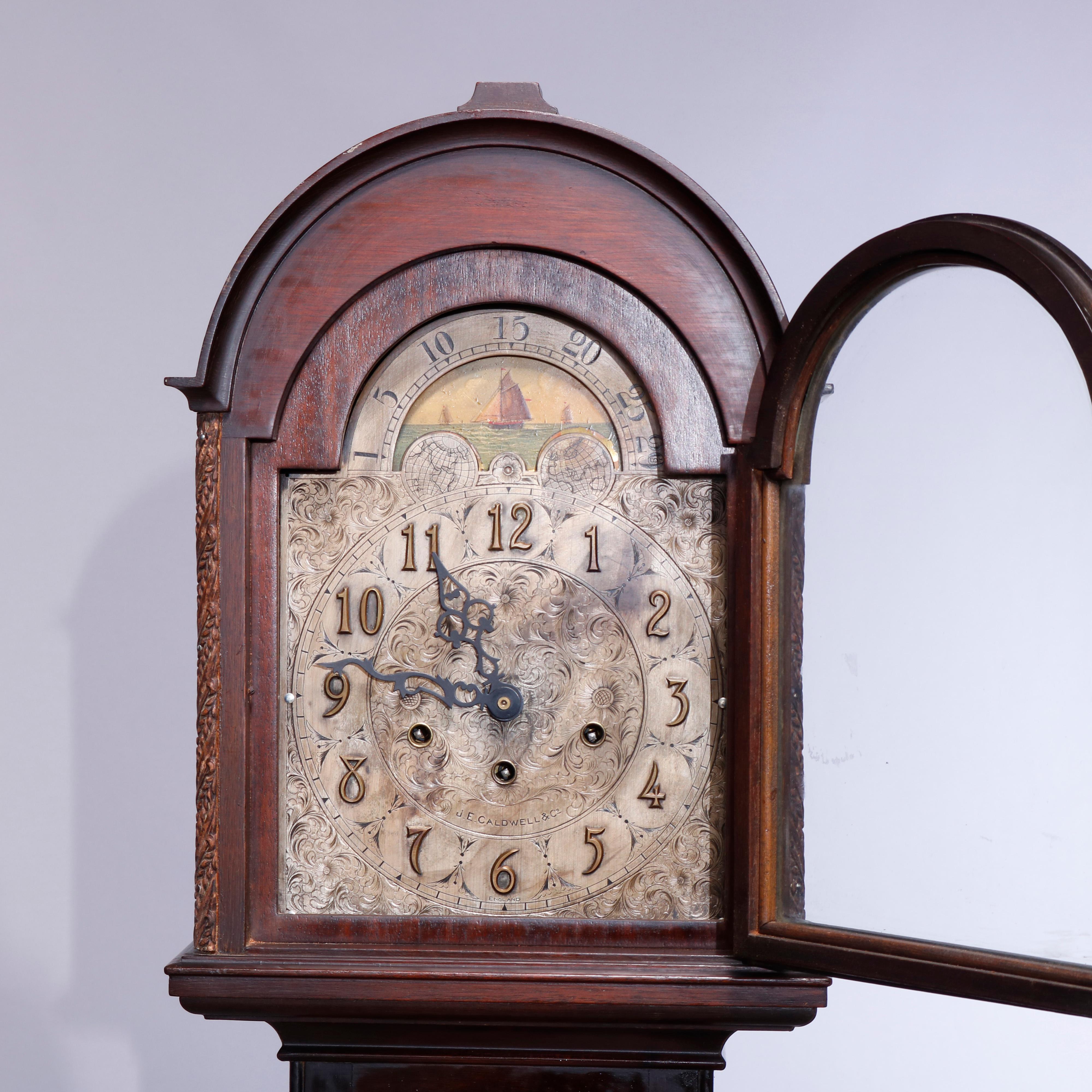 An antique grandmother's clock by J.E. Caldwell & Co. offers diminutive form with mahogany case with domed hood having moon phase dial over face with foliate cast filigree decoration, door with fleur de lis mount, signed on face as photographed,