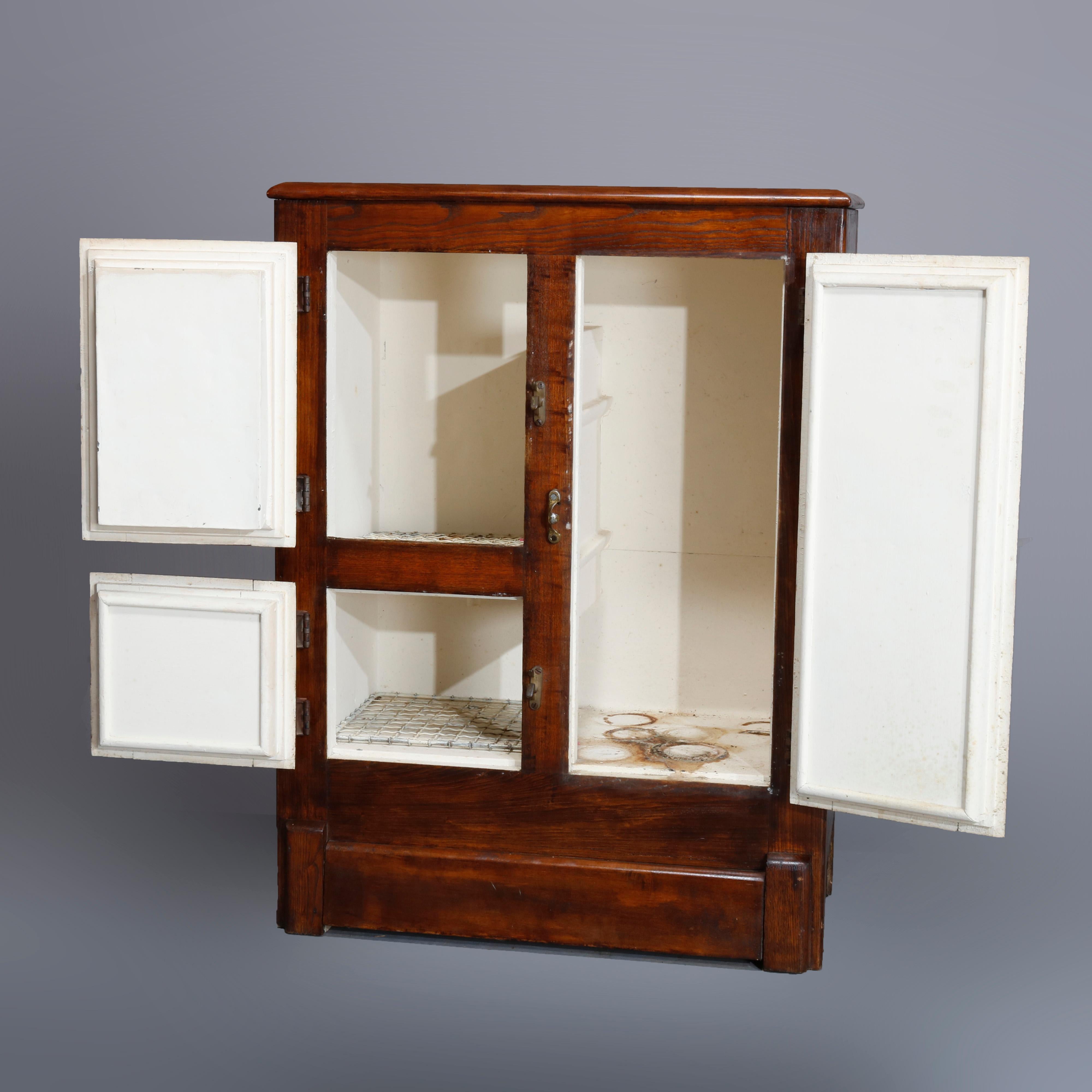 An antique diminutive ice box offers paneled oak construction with three doors, circa 1900

Measures- 36.18