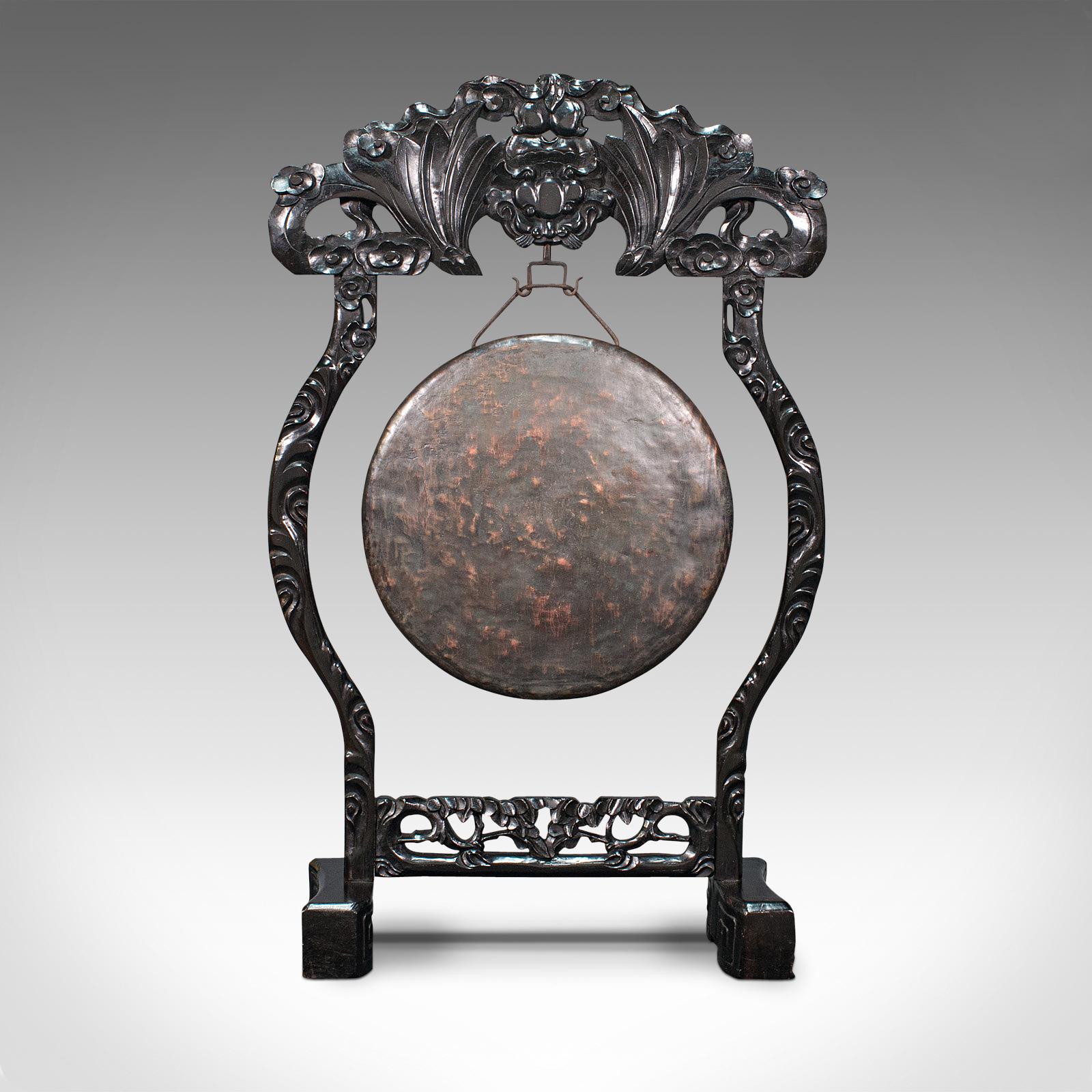 This is an antique dinner gong. An Oriental, ebonised teak stand with Chinoiserie taste hosting a bronze gong, dating to the Victorian period, circa 1880.

Elaborately carved stand ideal for the dinner hall - generous 3' tall frame
Displaying a