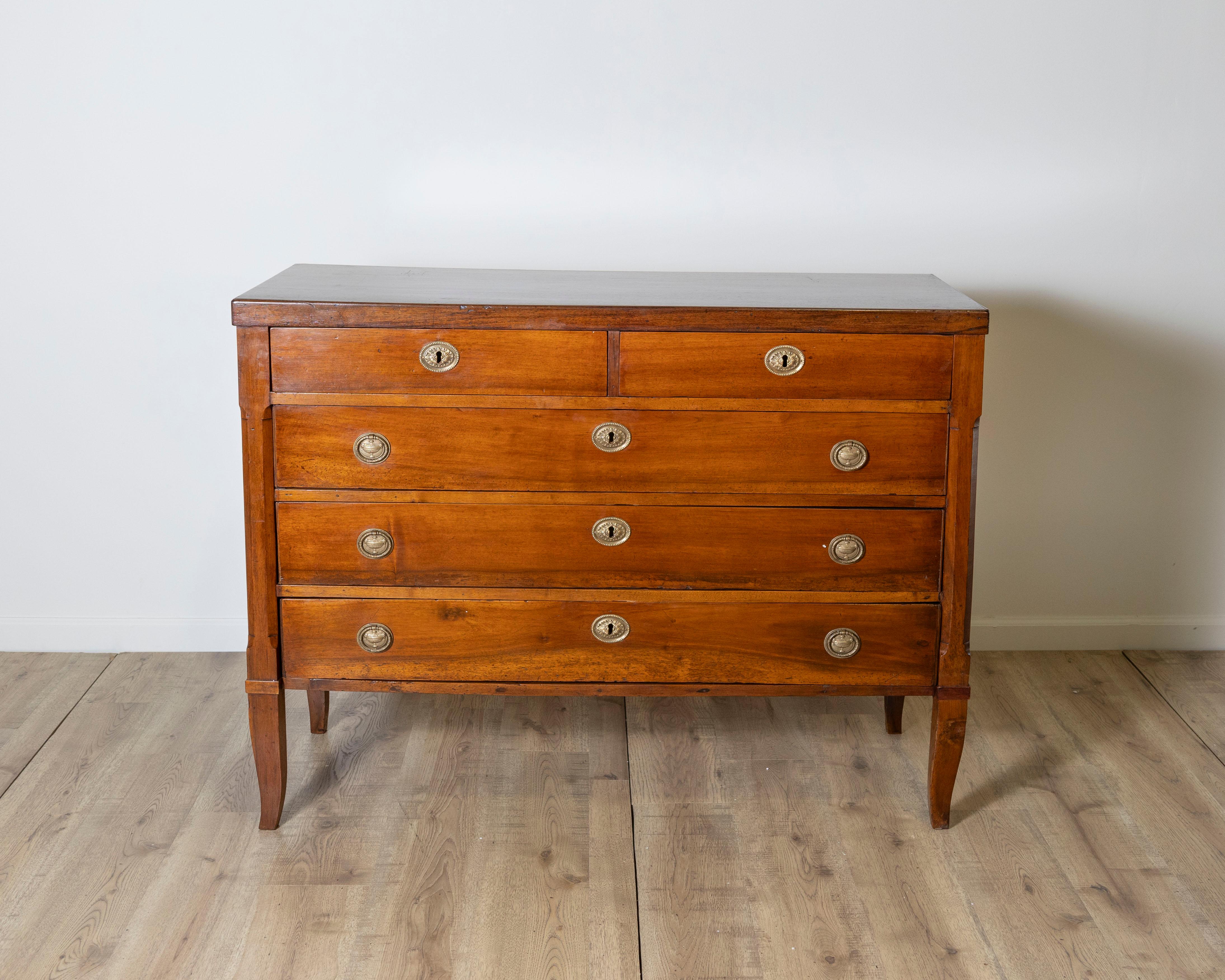 Cette élégante commode d'époque Directoire, réalisée en noyer massif, date de la fin du XVIIIe siècle et provient de la région italienne de Vénétie, haut lieu de la production de meubles raffinés à l'époque néoclassique. Sa silhouette sobre, typique