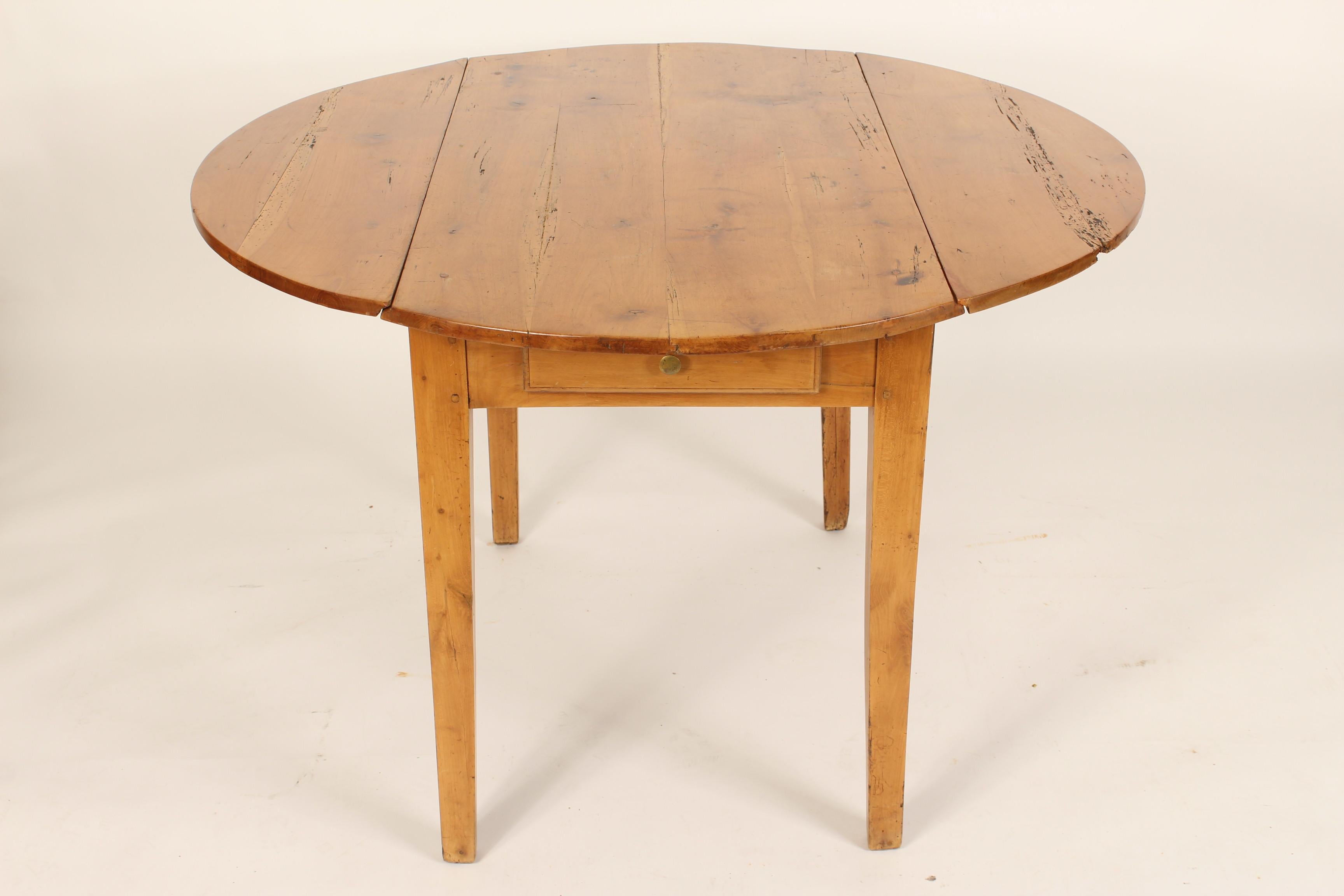 Antique Directoire style pine drop-leaf table, 19th century. Nice color and finish. This is a very versatile table that could be used as a small dining table, games table, occasional table or a sofa table. Diameter when both leaves are raised 44.5