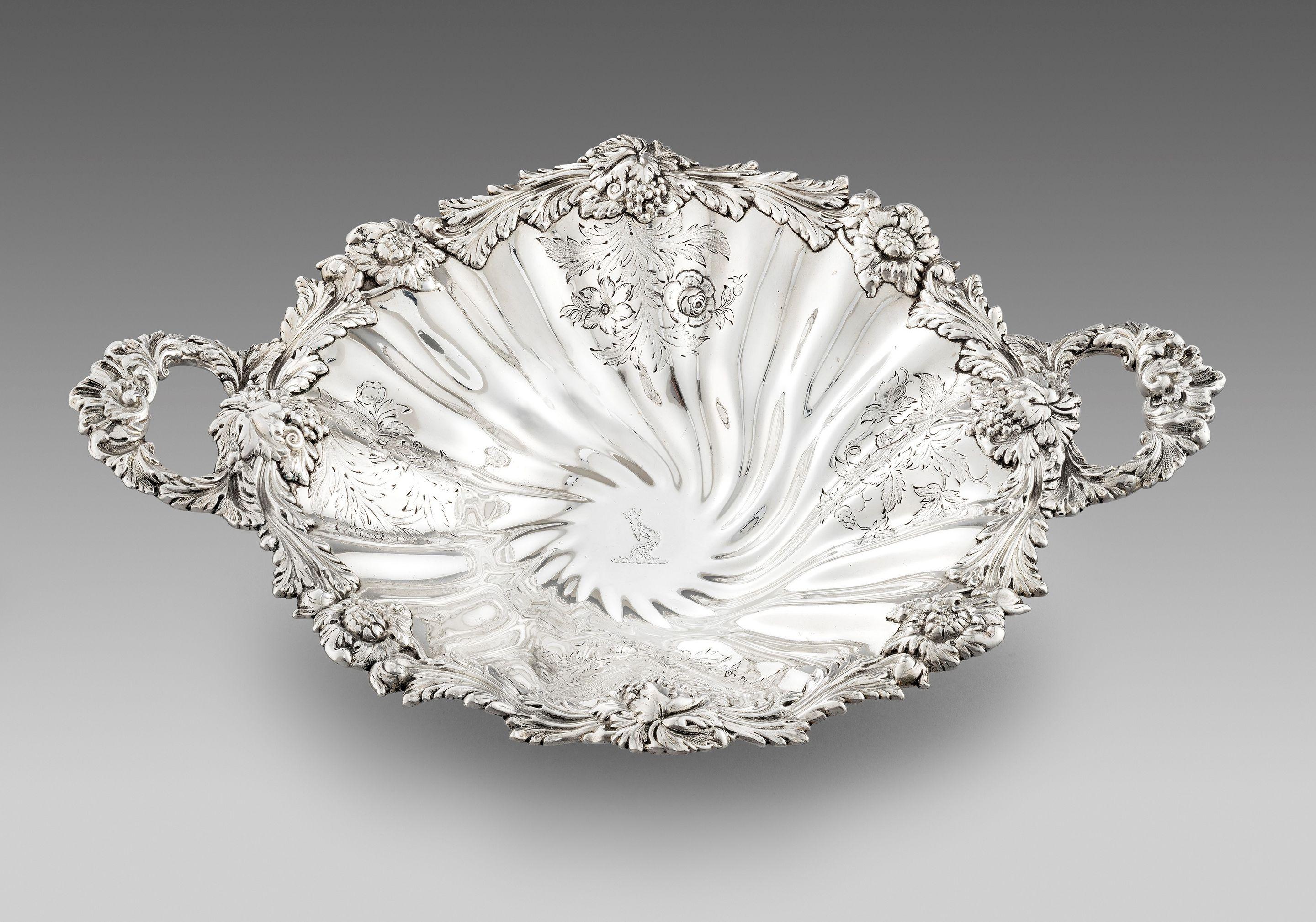 A beautiful Antique dish made in the reign of William IV , in 1833 . The two handled dish is of round shaped form with an impressive border depicting grapes, flowers and foliage. The decoration is repeated on the fluted body and the centre is
