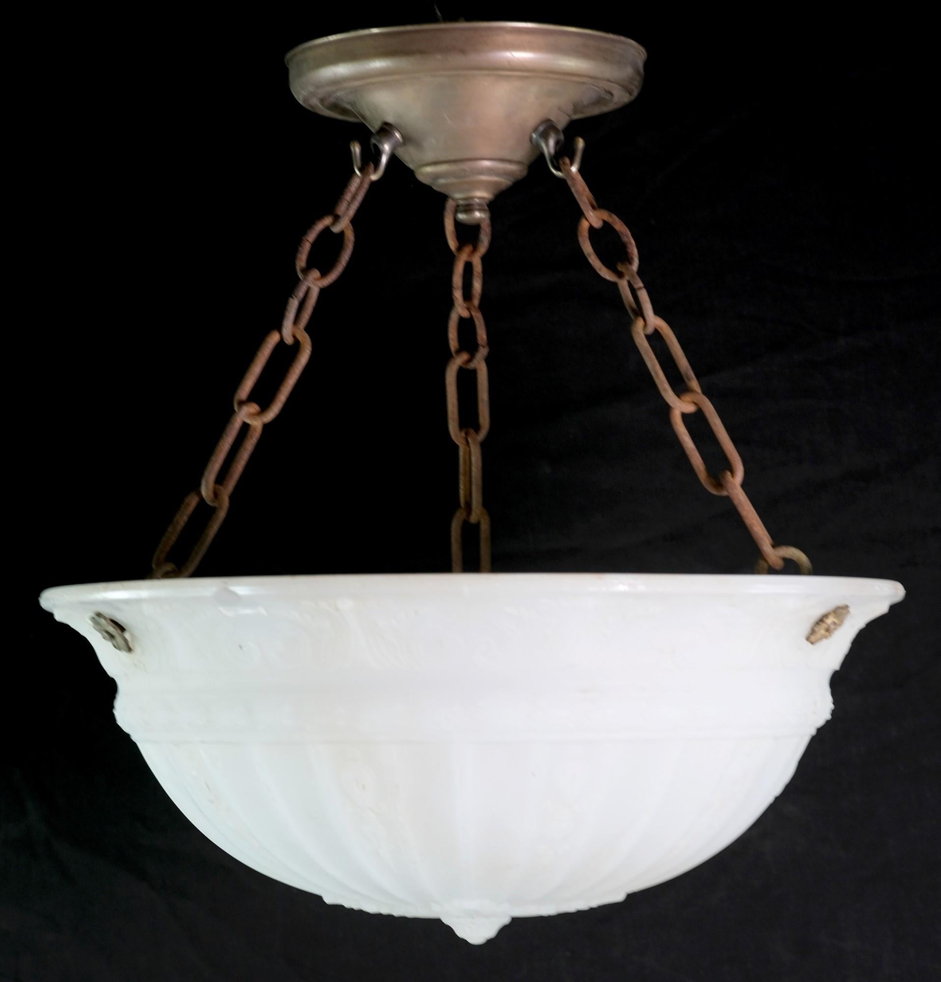 Early 20th century dish pendant light featuring a cast white shade ornate foliage detail. Minor chips in the glass. Pictured with brass and iron hardware with a rusted patina. Ornate floral rossettes. Cleaned and rewired. Small quantity available at