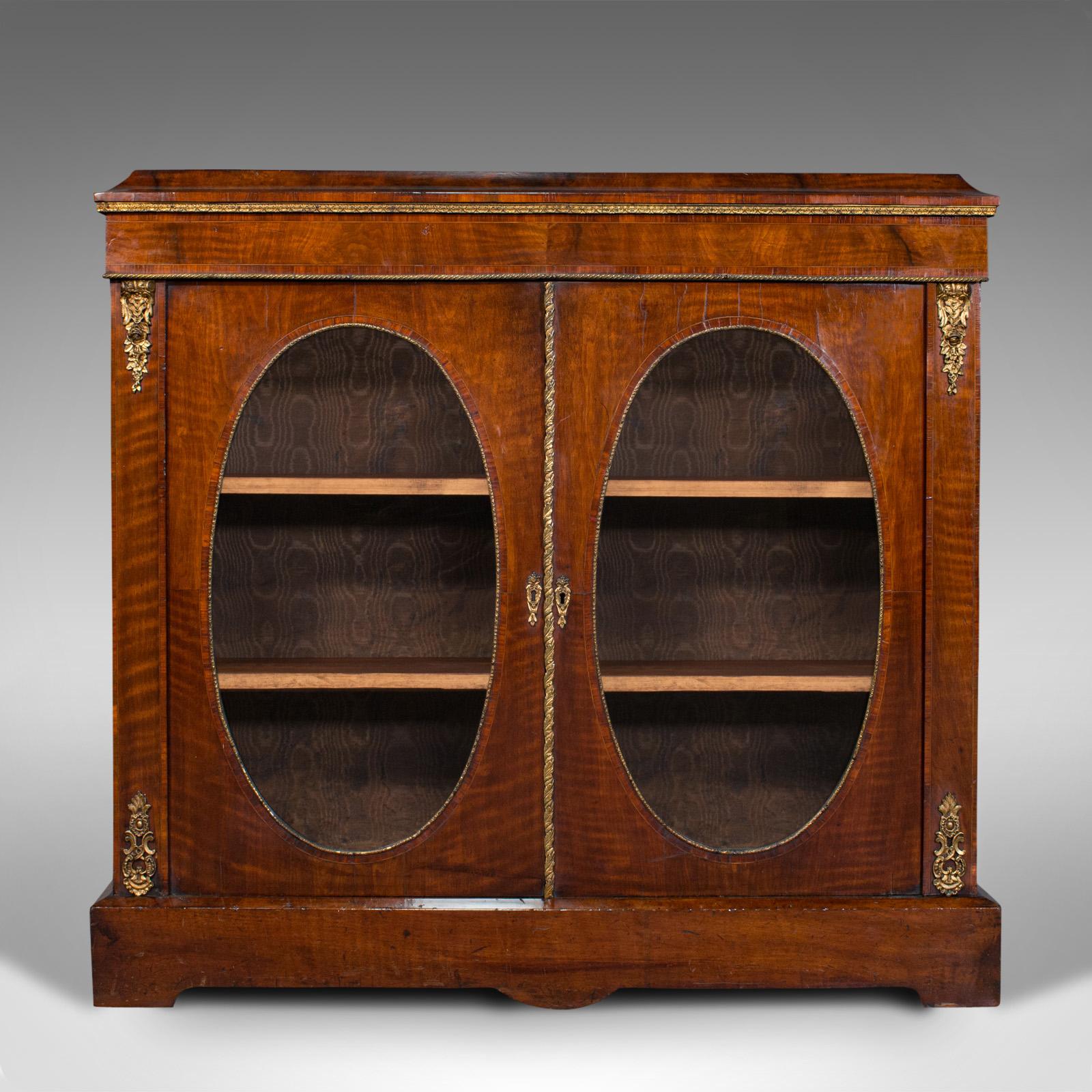 This is an antique display bookcase. An English, walnut, boxwood inlay and ormolu dressed Empire cabinet, dating to the Regency period, circa 1820.

Attractive example of Regency period library furniture
Displaying a desirable aged patina and in