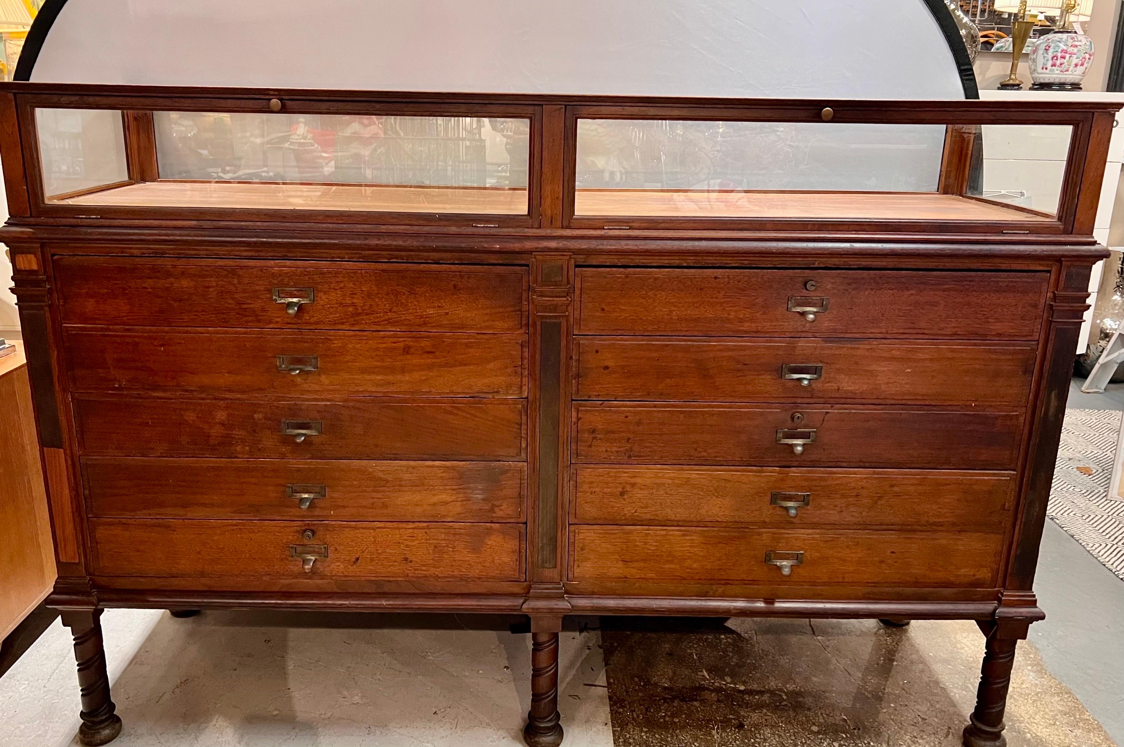 Beautiful rare antique mahogany display case vitrine with 2 display compartments on top that open in the front. There are 10 drawers, 5 on each side underneath glass doors. Back is also finished.  All original hardware.