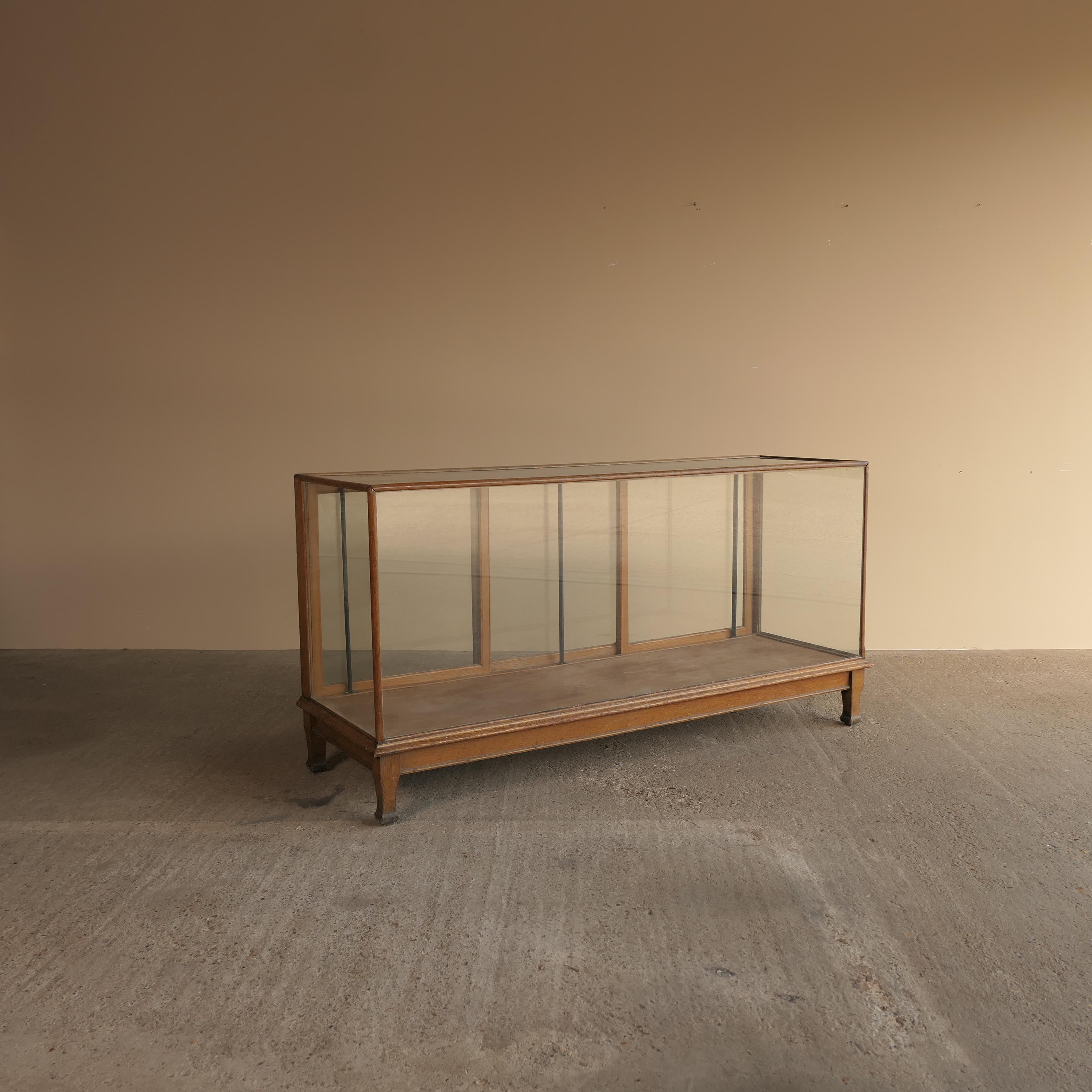Rare Victorian display cabinet or shop counter, crafted in the late 1800s by F. Maund & E. Berg Showcases Ltd, London. This antique piece features a solid oak frame with original glazing on all sides, offering full visibility and timeless appeal.