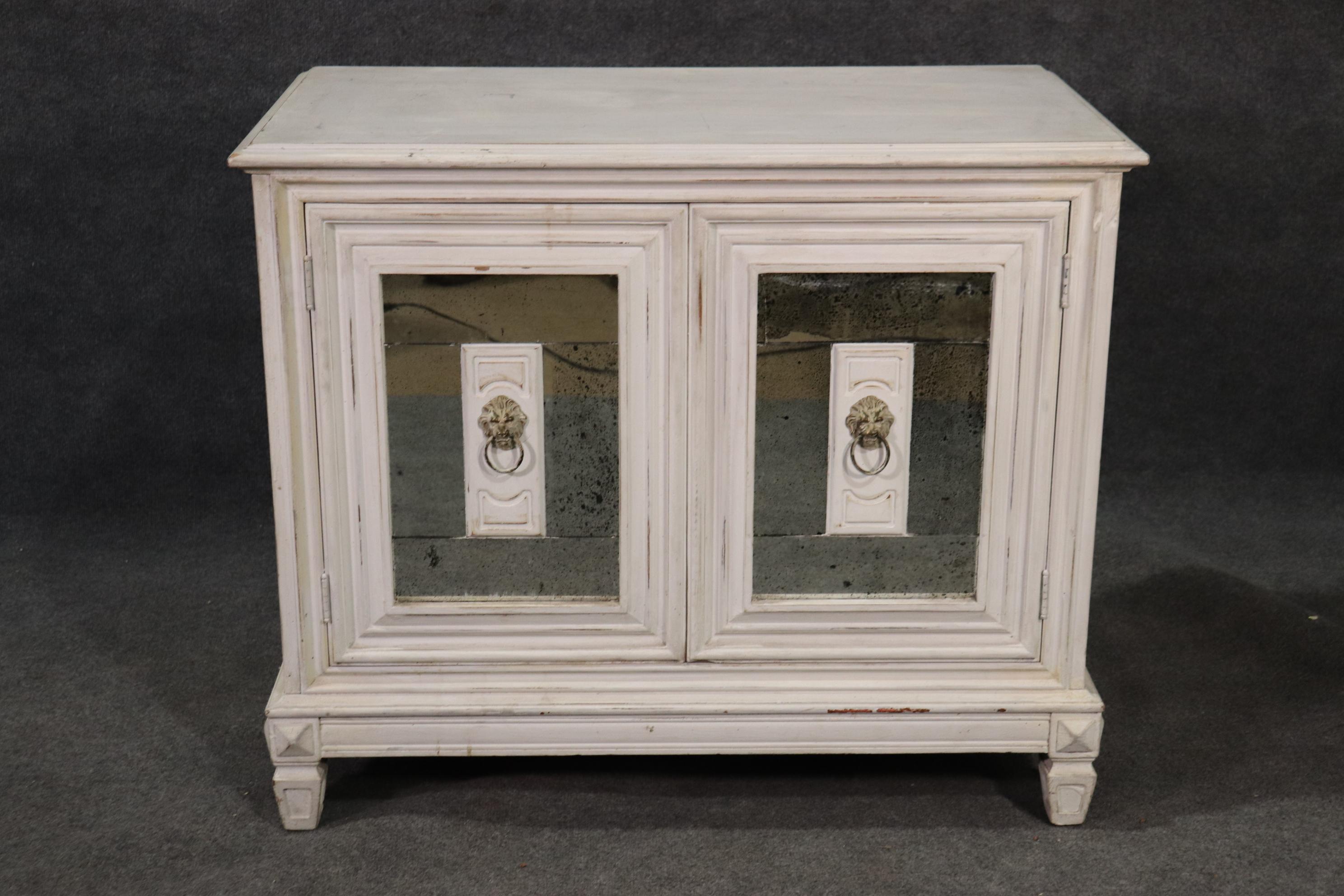 This beautiful commode has a beautiful pair of antique-patinated mirrored panels and a white distress painted background. The cabinet measures 32 tall x 38 wide x 20 deep.