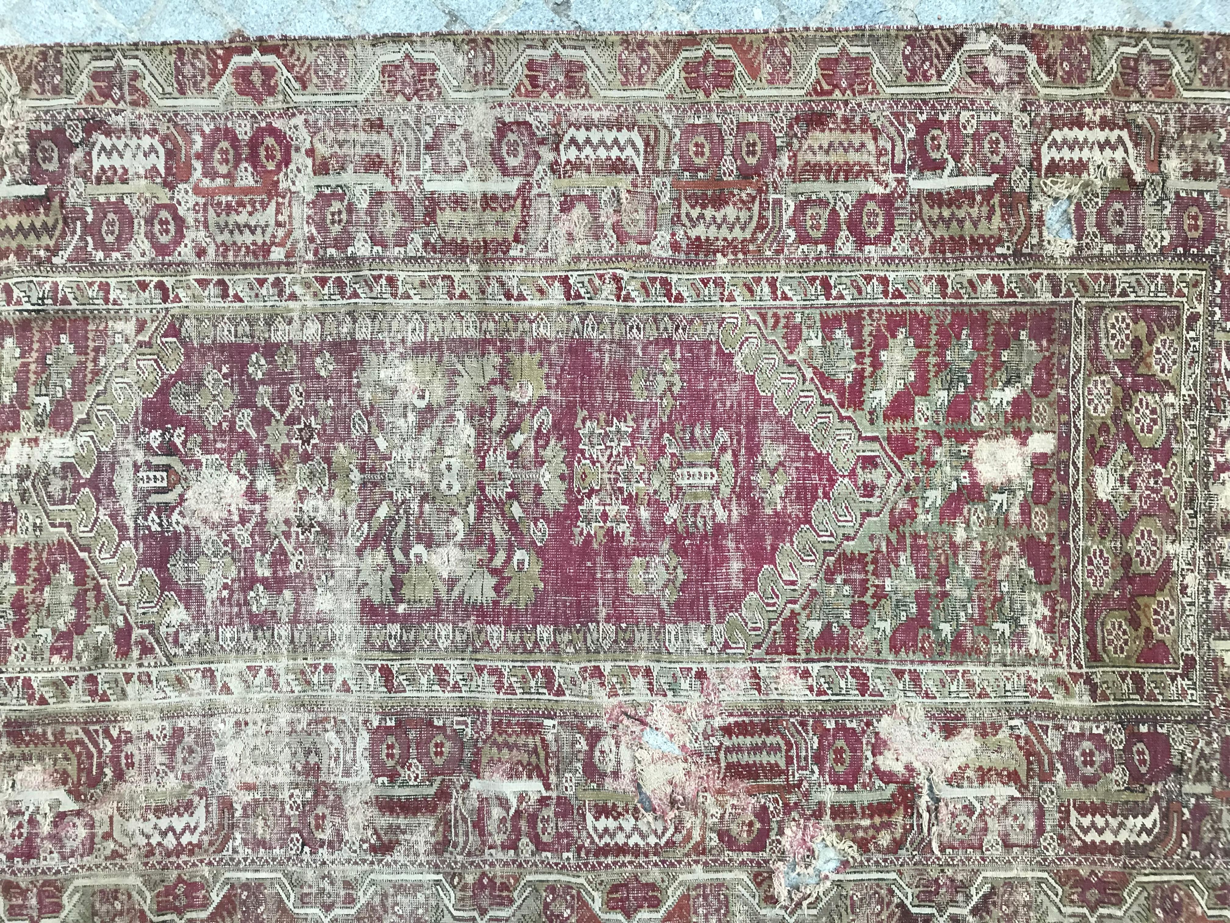 A distressed antique Turkish rug late 18th century with nice Mihrab design and natural colors with purple, brown and green, entirely hand knotted with wool velvet on wool foundation.