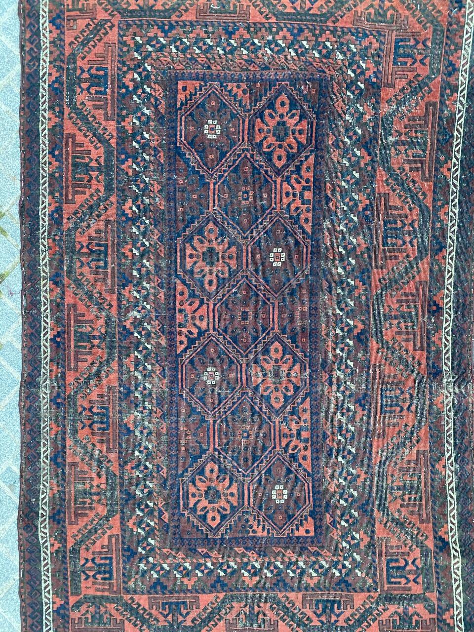 Magnifique tapis Baluch antique au design tribal géométrique et aux couleurs naturelles, entièrement noué à la main avec du velours de laine sur une base de laine.