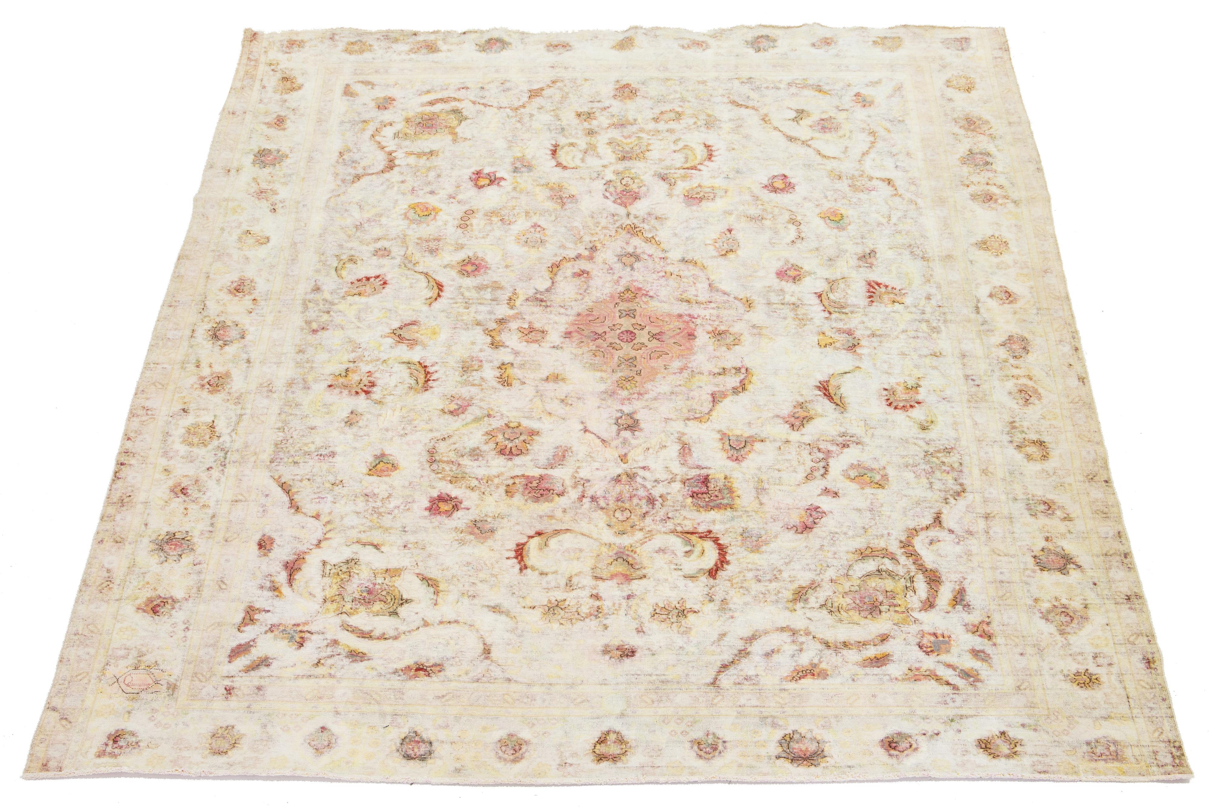This handmade Persian Kerman wool rug showcases a beige field adorned with yellow and red accents throughout.


This rug measures 9'5