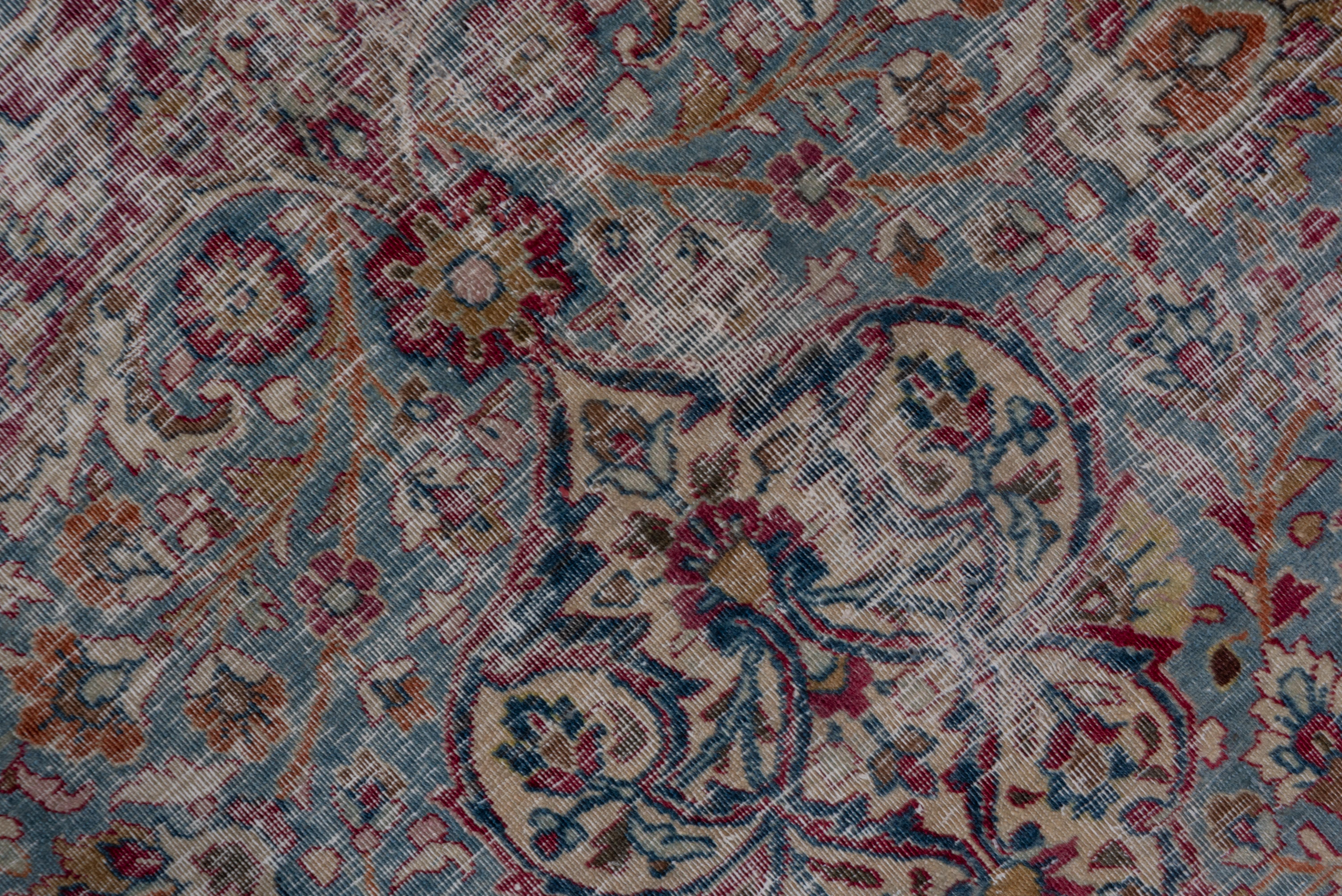 This NE Persian carpet shows a pointed and lobed doubly pendanted round sand medallion with interior forked arabesques, all set on a shaped teal Sub-field, surrounded by a dark wine ground and tonally similar main border of double tendrils and petal